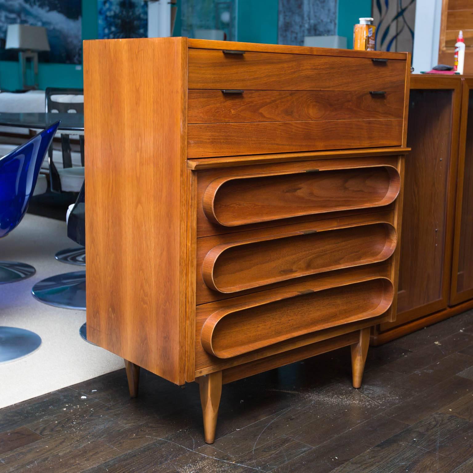 The only marking on this spectacular piece is the production date stamped on the back of 1962. Really cool sculptural fronts with walnut bands and brass accents form the drawer pulls. Detachable two-drawer shaving mirror sits on top matching low