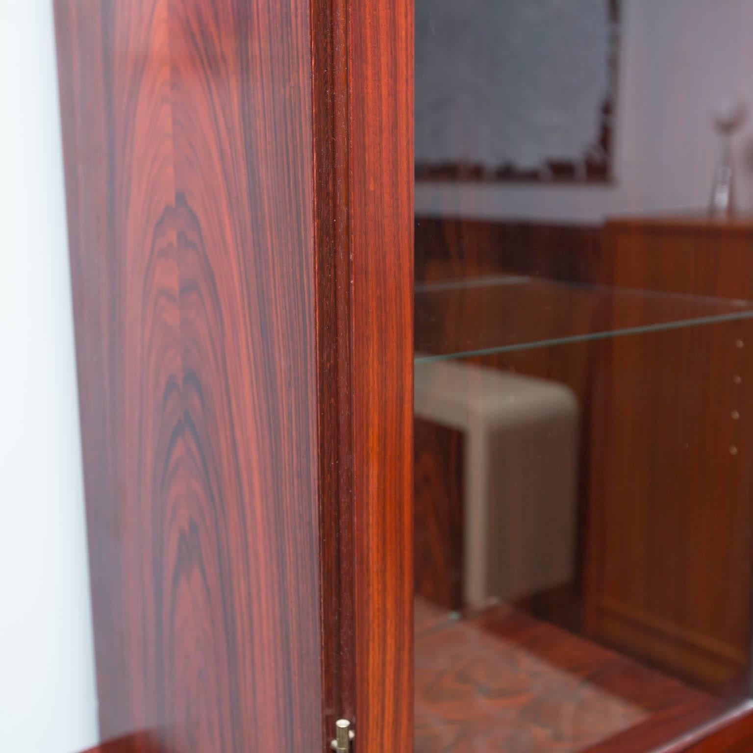 Generous two-piece rosewood cabinet plus sideboard. Top section features interior lighting and ten adjustable glass shelves with plate grooves; bottom includes interior shelves and a set of five felt-lined drawers.