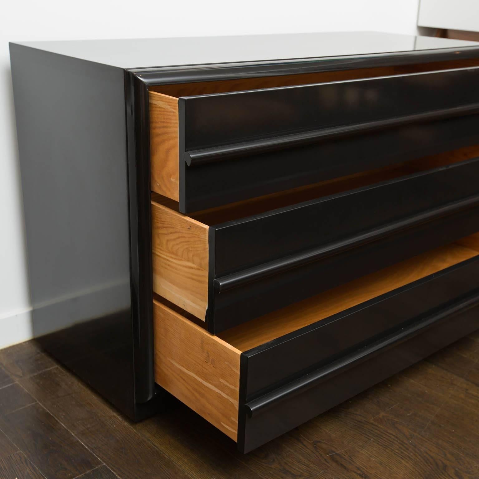 Freshly lacquered in high gloss ebony, this version of a long, three-drawer low dresser is rarely seen.