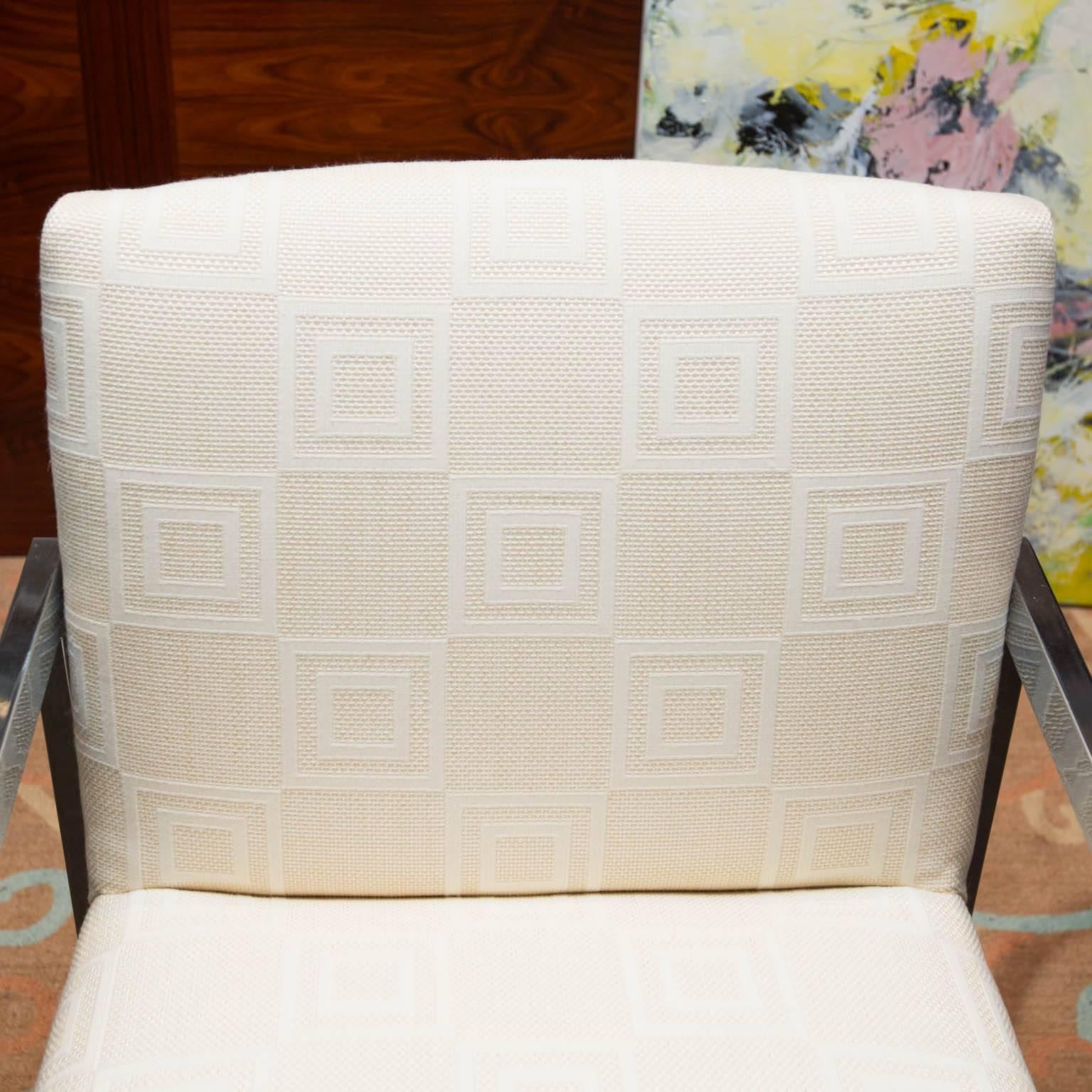 Vintage solo piece in the manner of Milo Baughman's designs for Thonet. Reupholstered in a checkered graphic white on white fabric, with gleaming chrome arms and frame.