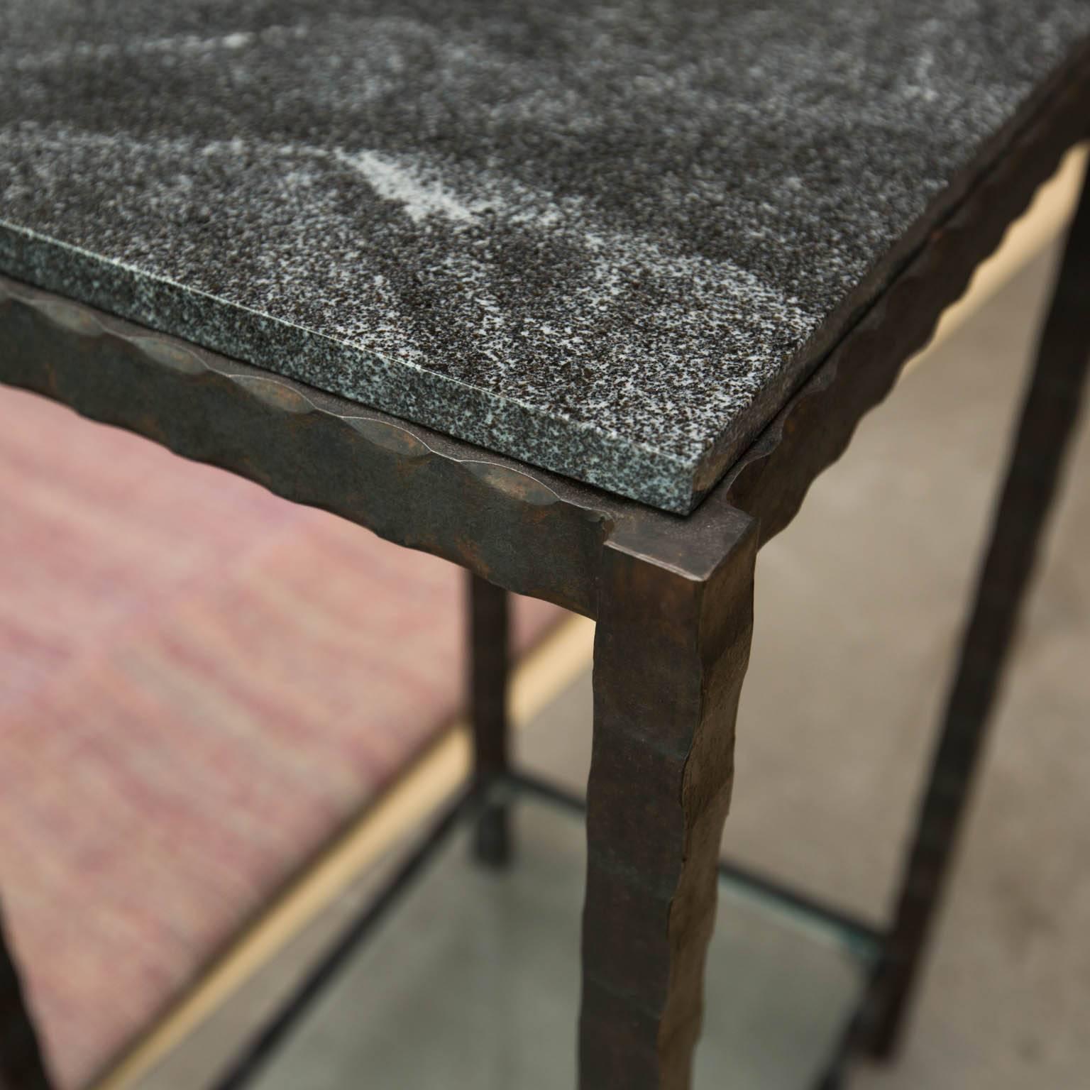 Compact but substantial side table made from hand-forged patterned steel with a forged wave edged granite. Features a single glass shelf.