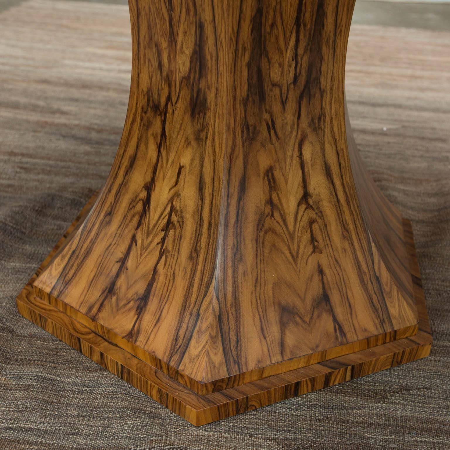 Elliptical shaped custom made table by award-winning furniture designer Gregory Clark. Formed from bookmatched Bolivian rosewood veneers atop a six sided base with matching veneers on each side.