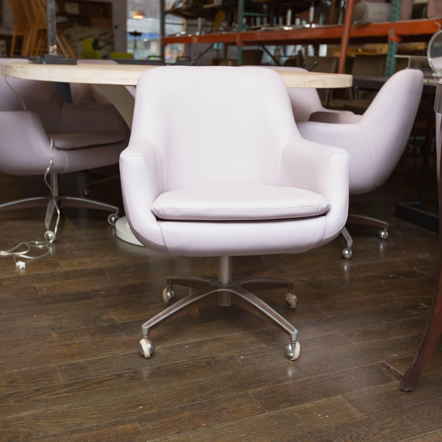 Covered in a mauve Naugahyde, these five chairs hail from the 1970s. Vintage castors still allow chairs to glide smoothly and chairs swivel just as readily.