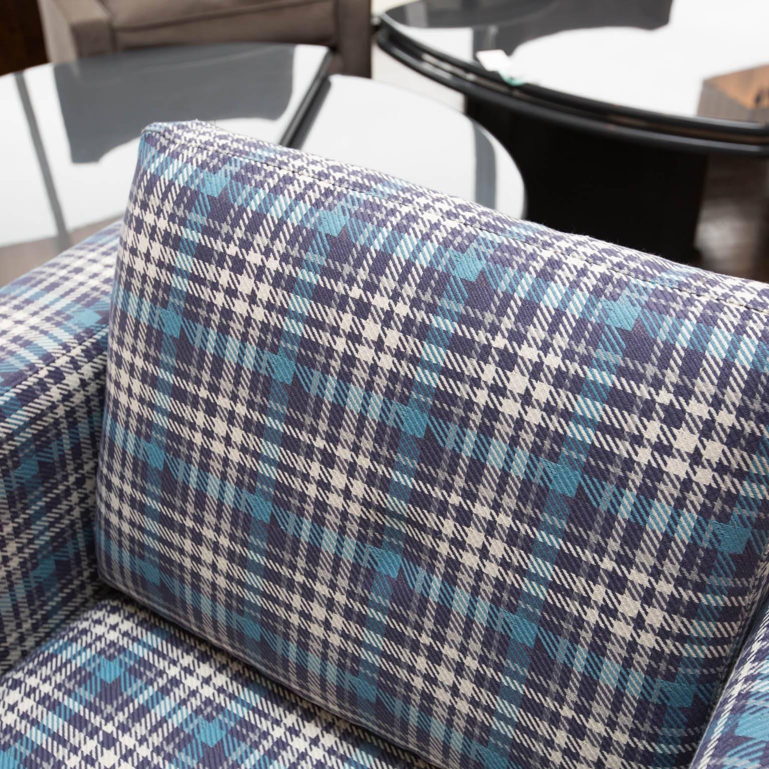 Heavy chairs with smooth swivel action, newly reupholstered in a cool, tartan plaid fabric.