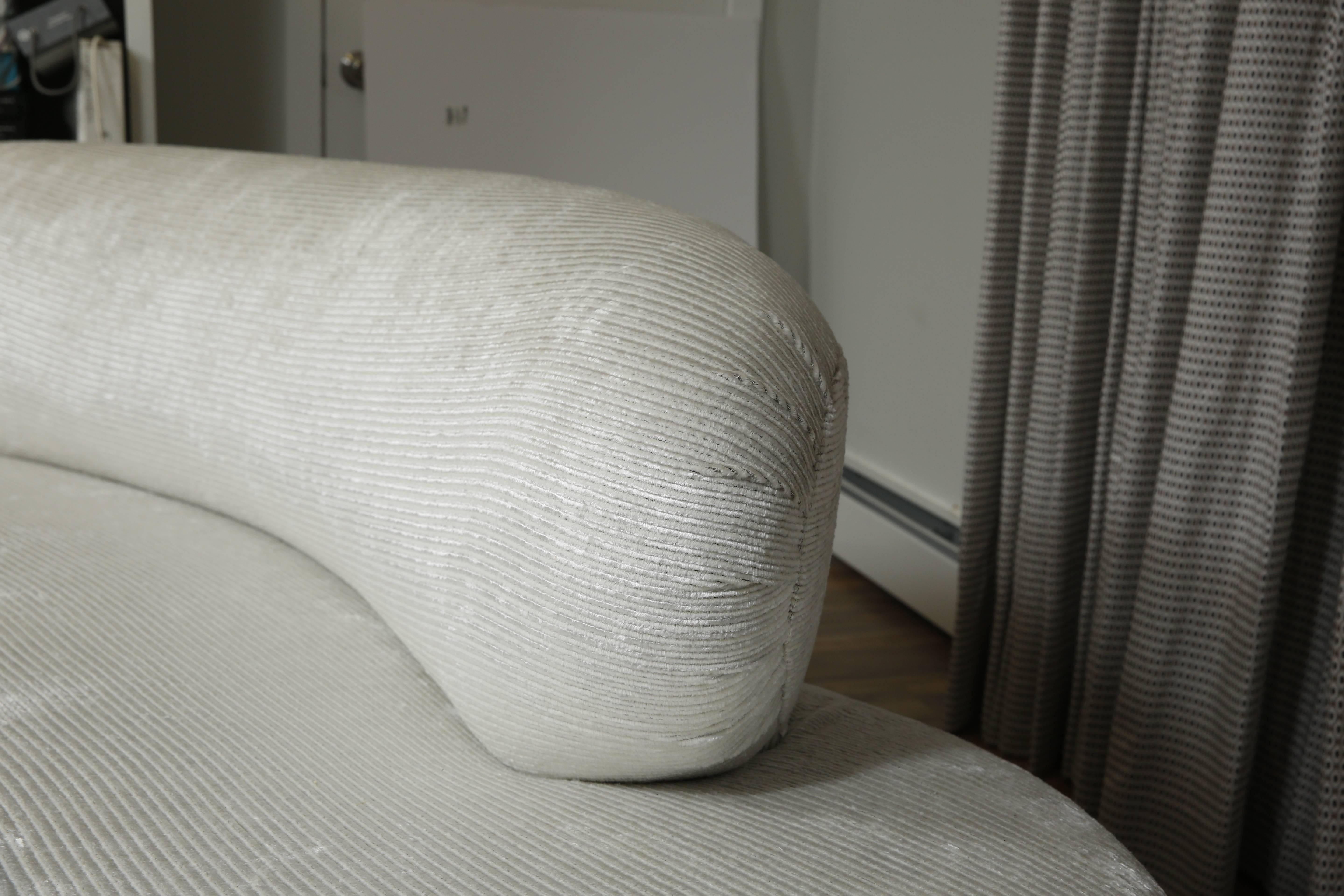 Iconic biomorphic sofa. Reupholstered in off white linen and resting on brushed aluminum trimmed pedestals.