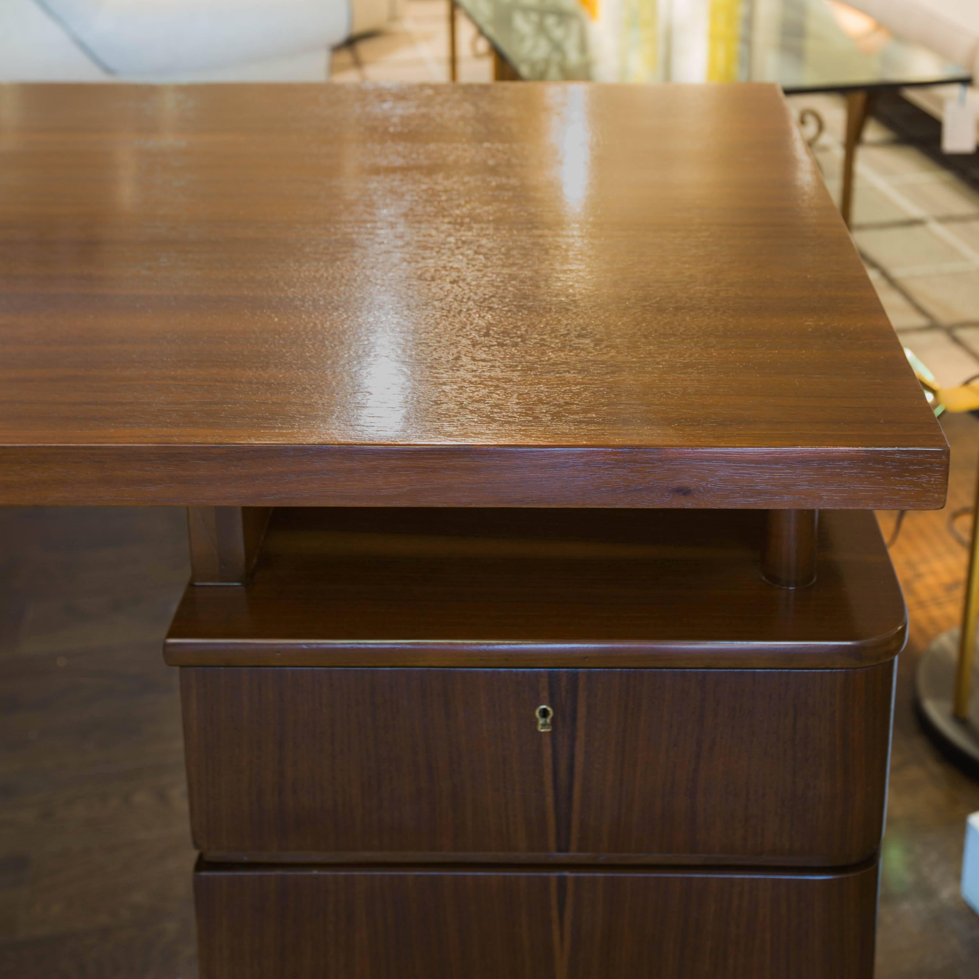 Machine Age design walnut desk with 3 drawers (top one locks with key) and a floating top. Newly refinished.