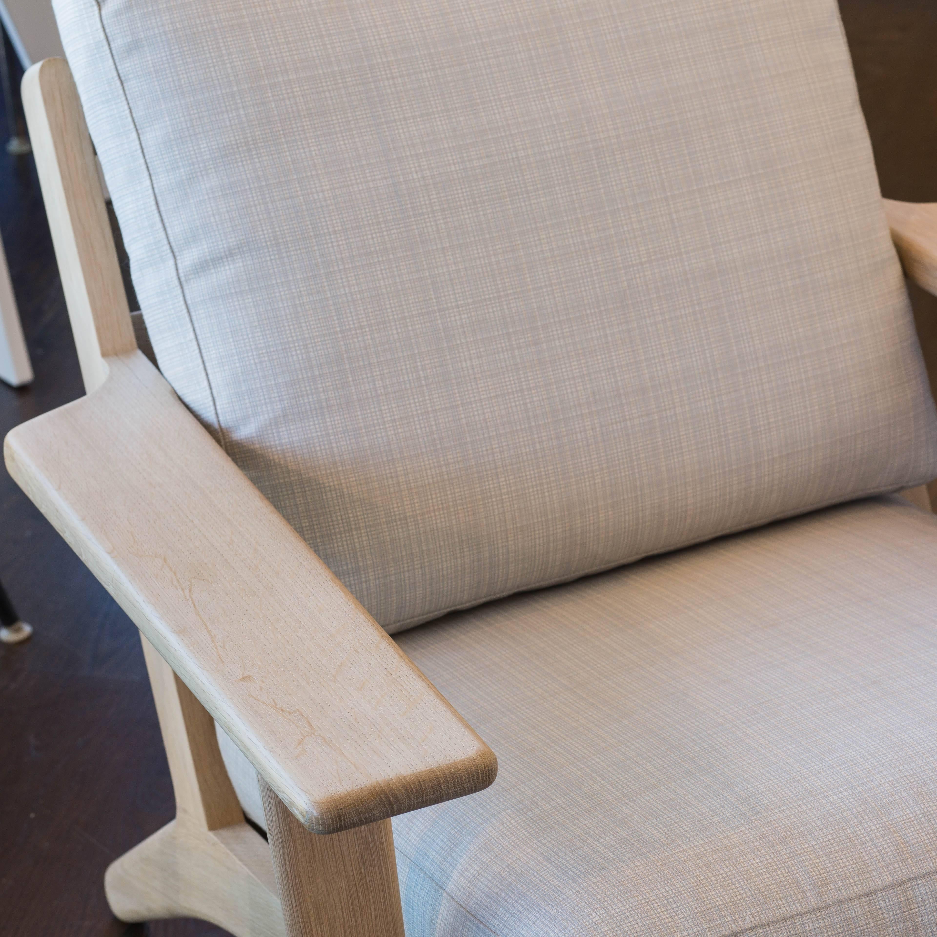 Designed by Wegner in 1953 and re-issued today by the original manufacturer GETAMA of Denmark this easy chair is featured in natural oak with off-white linen/down filled cushions.