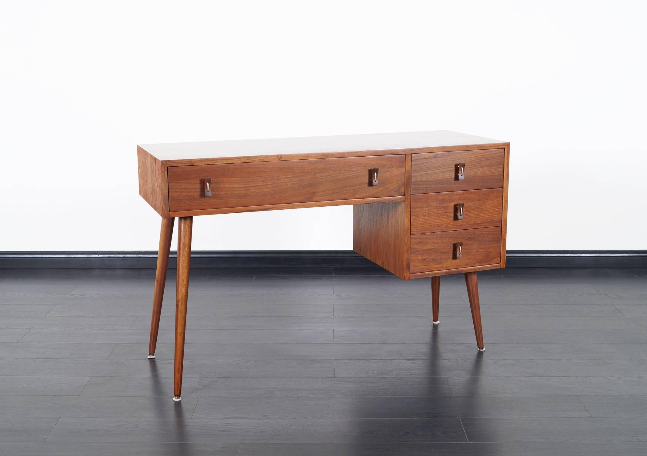 Vintage walnut desk designed by Stanley Young for Glenn of California. Features two drawers and one file drawer with sculpted handles.