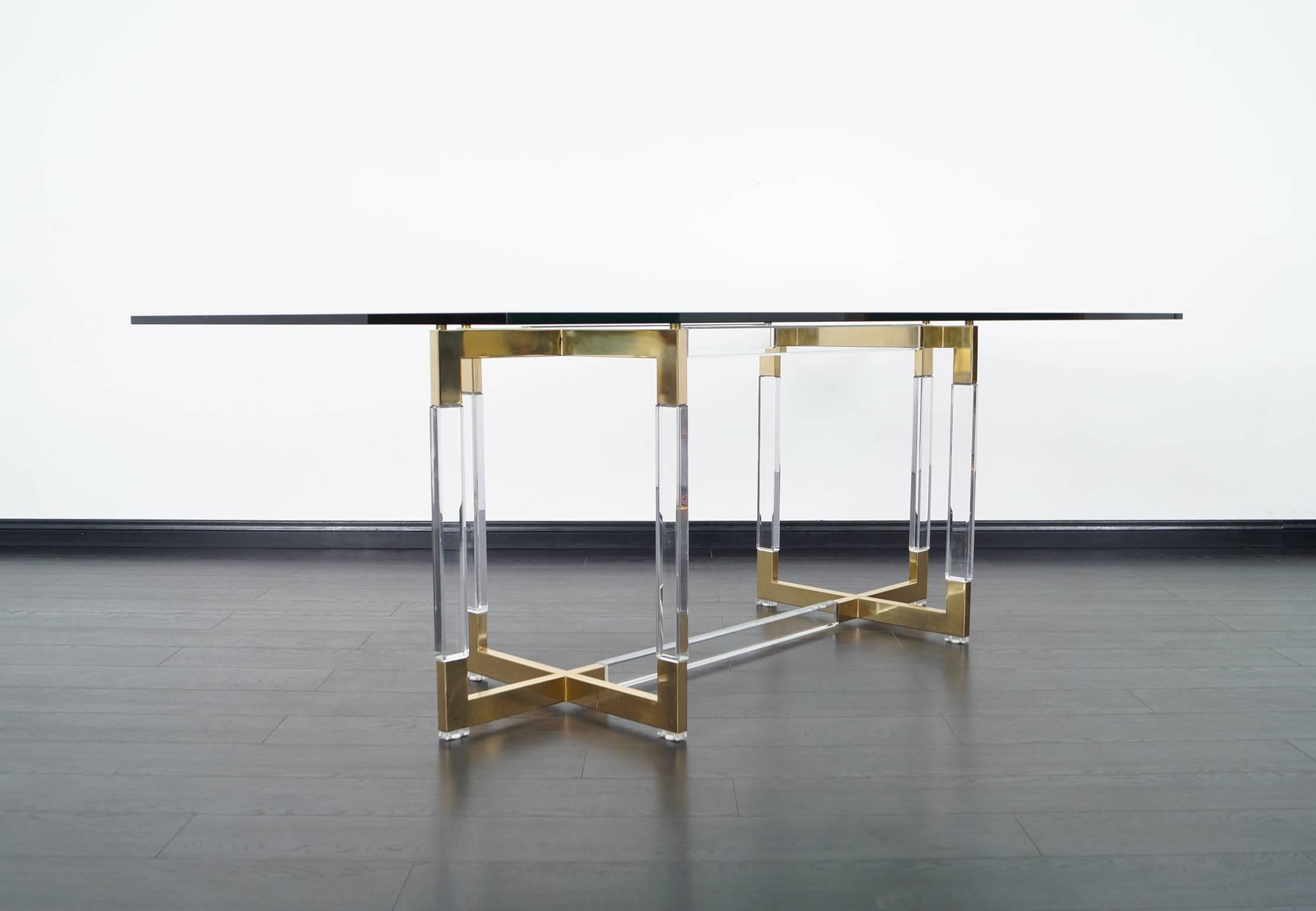 A stunning vintage lucite and brass dining table designed by Charles Hollis Jones for the 