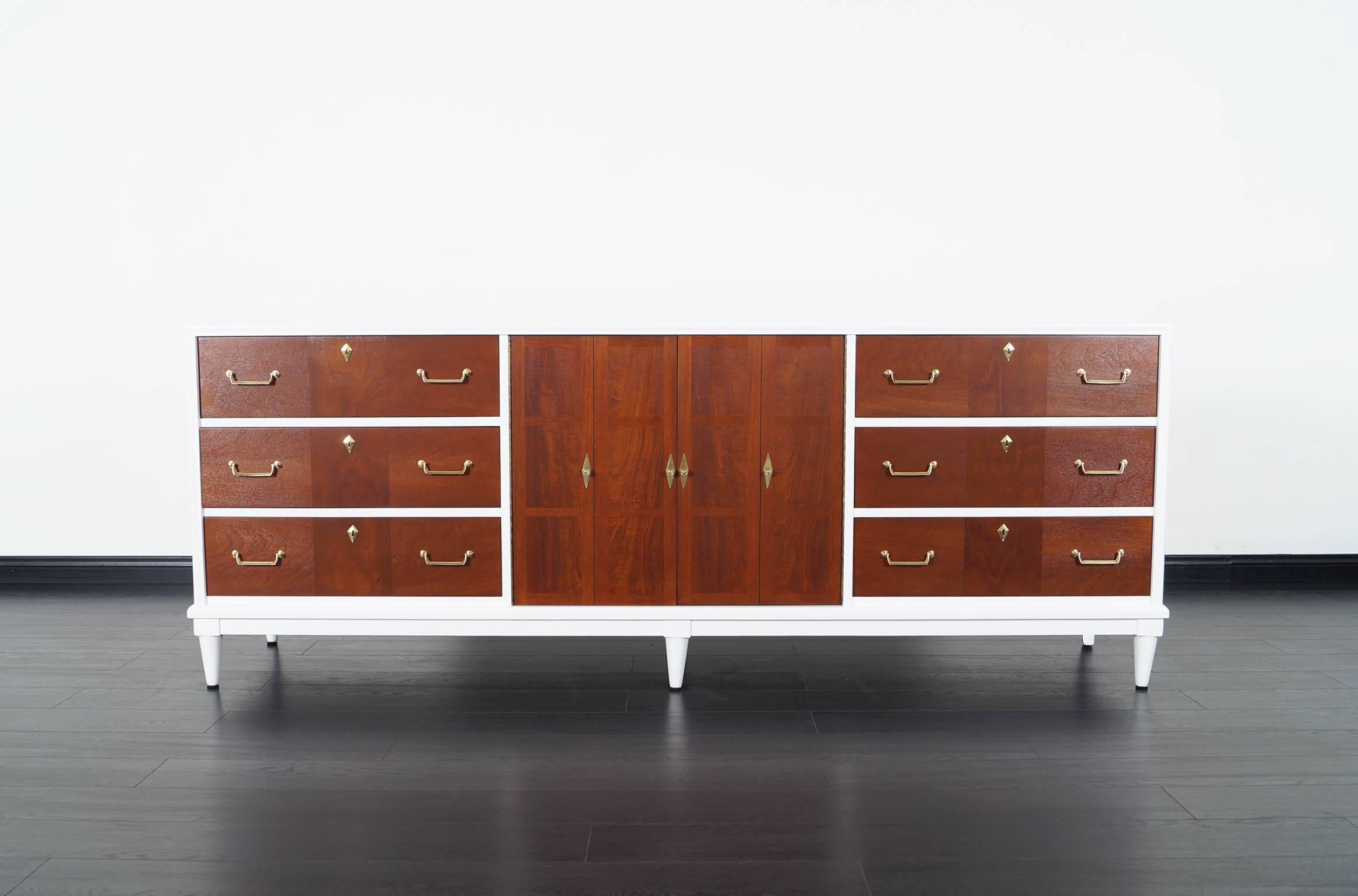 Vintage two-tone credenza by American of Martinsville. Contains a total of nine dovetail drawers, three are hidden behind two doors.