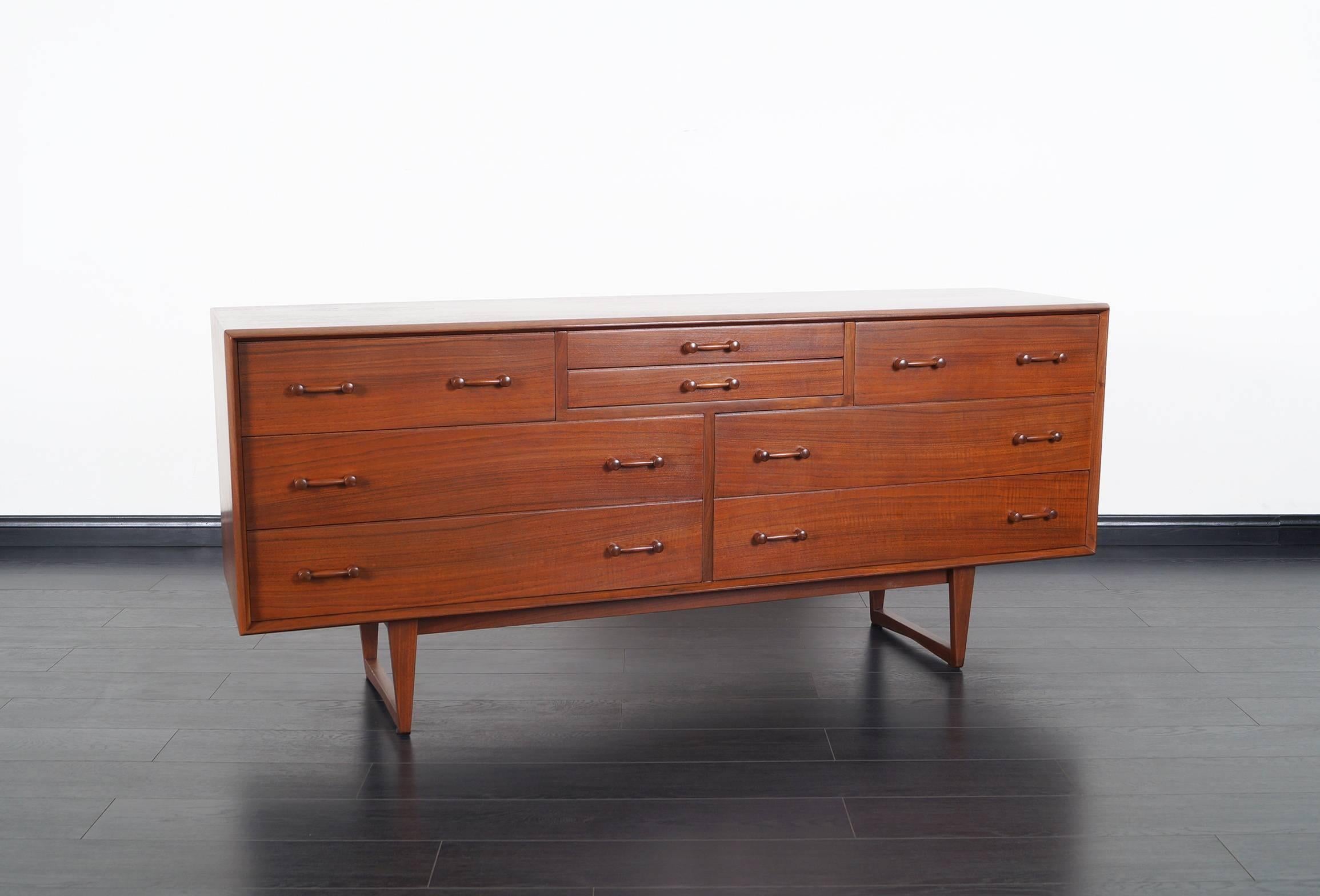 Danish modern walnut dresser. Features eight dovetail drawers with sculpted handles and legs.
  