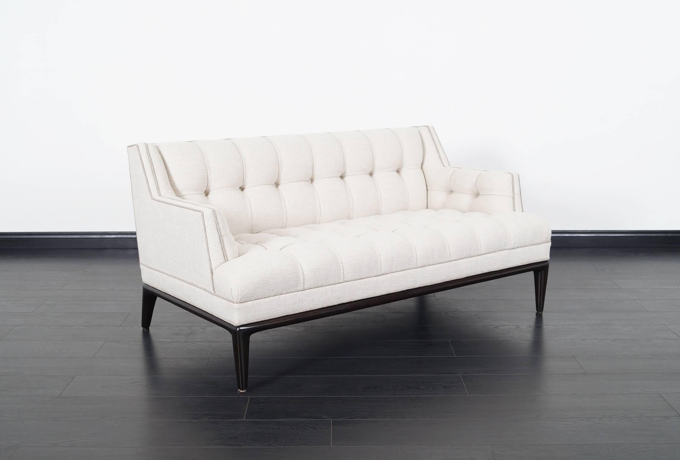 Beautiful biscuit tufted loveseat designed by Maurice Bailey for Monteverdi-Young. Exquisitely sculpted ebonized mahogany tapered legs. Retains original label.