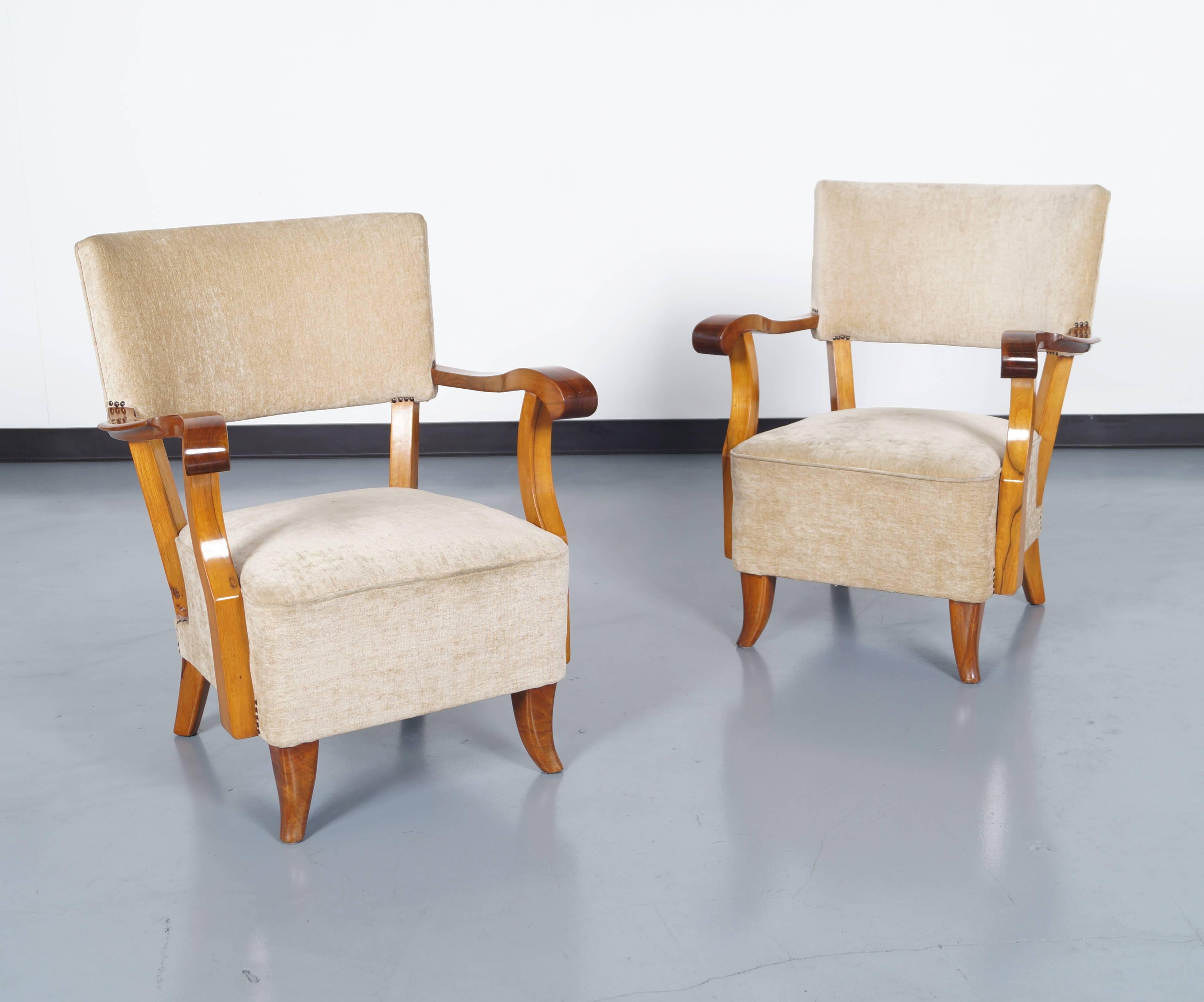 Exceptional pair of Art Deco lounge chairs produced in France, 1930s. Fabulous walnut grain. Underneath the seats it contain original coil springs for superior comfort.