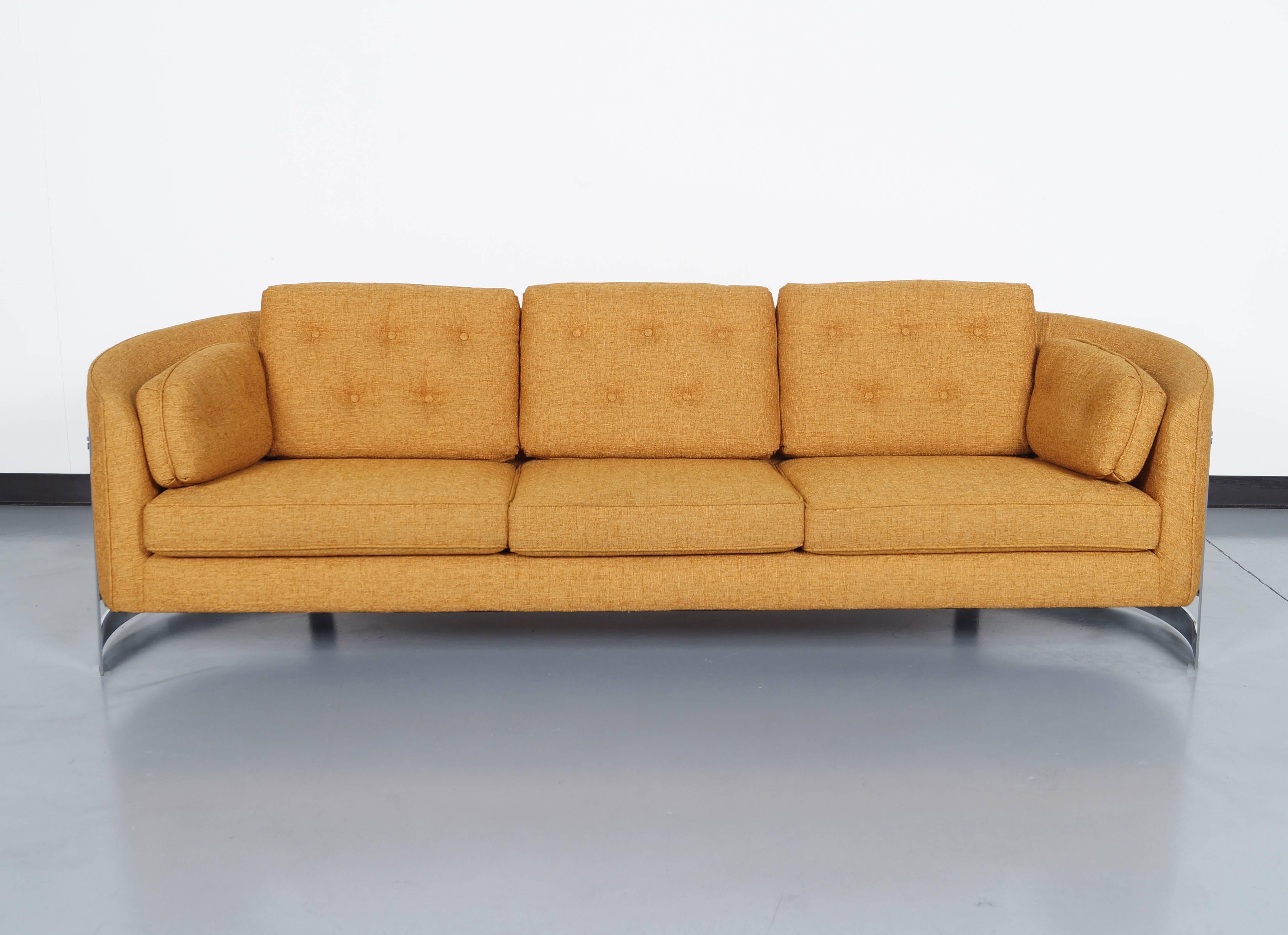 A stunning vintage floating chrome sofa attributed to Milo Baughman in United States circa 1970s. This sofa has been professionally reupholstered in a burnt orange tweed fabric, it shows a modern and avant-garde design expressed through the curves