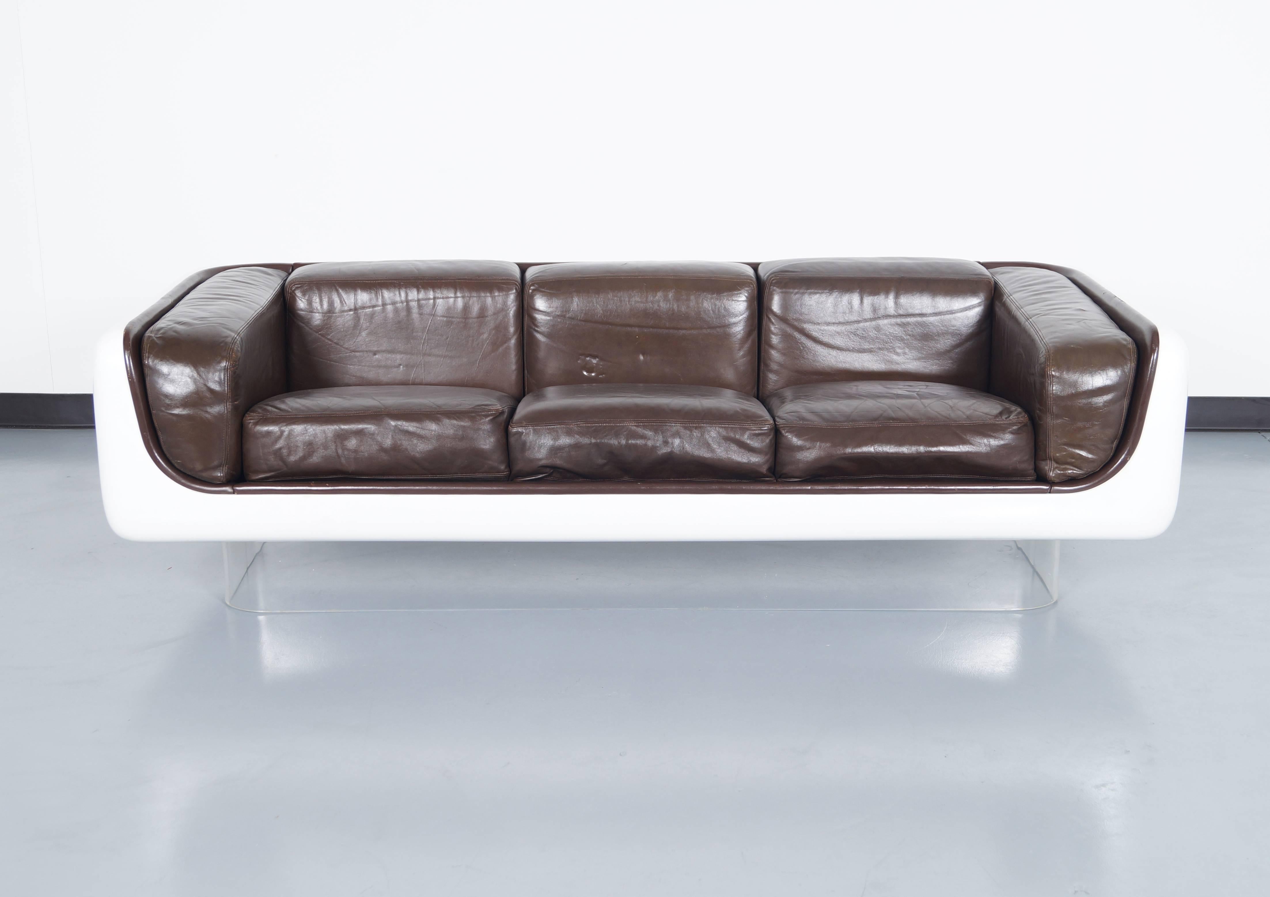 Vintage fiberglass case sofa with lucite base. The lucite gives the appearance that the sofa is floating. Designed by Steelcase.