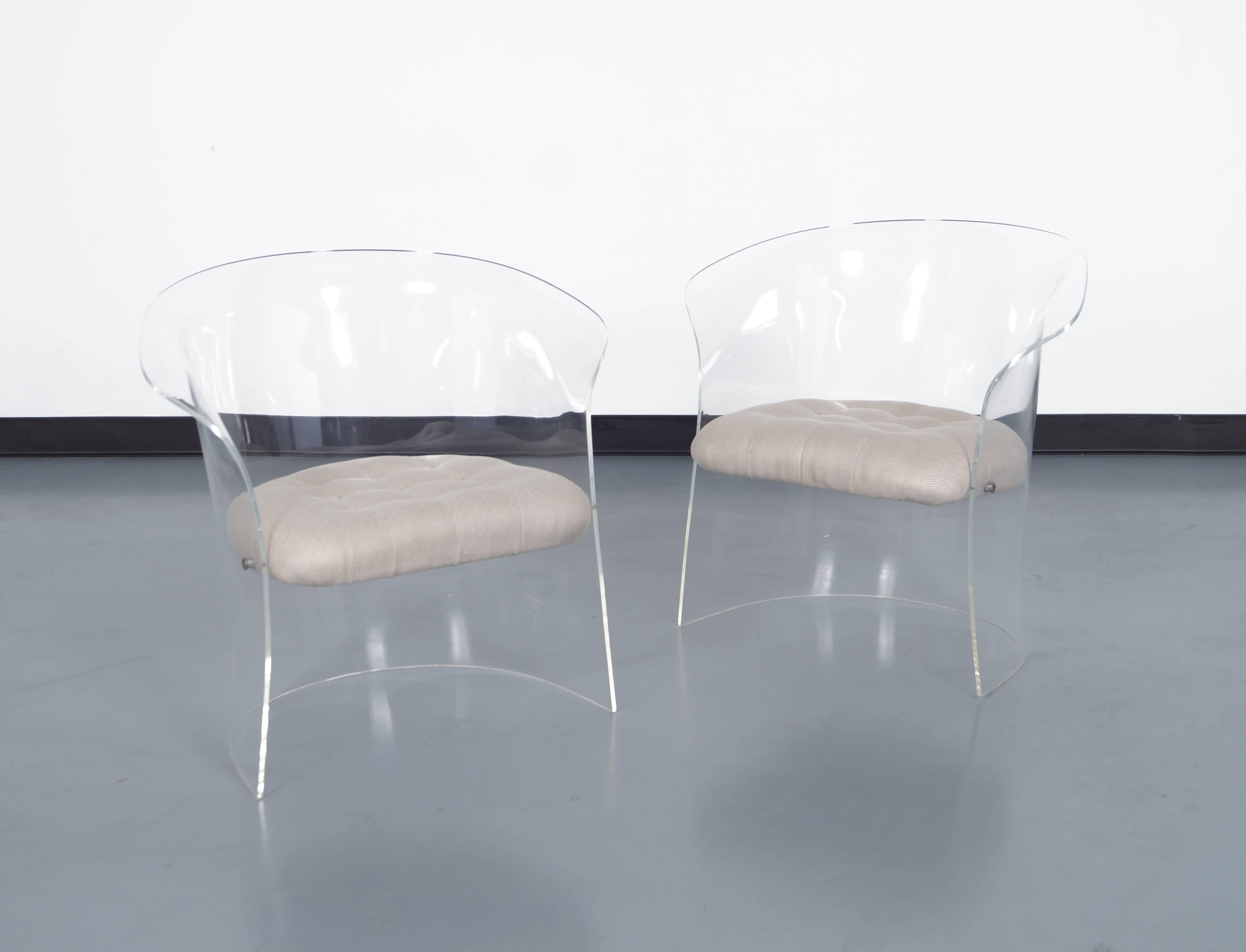 Pair of flexuous Lucite lounge chairs, circa early 1970s. These chairs have curved backs and sides. The seats are attached by chrome covers.