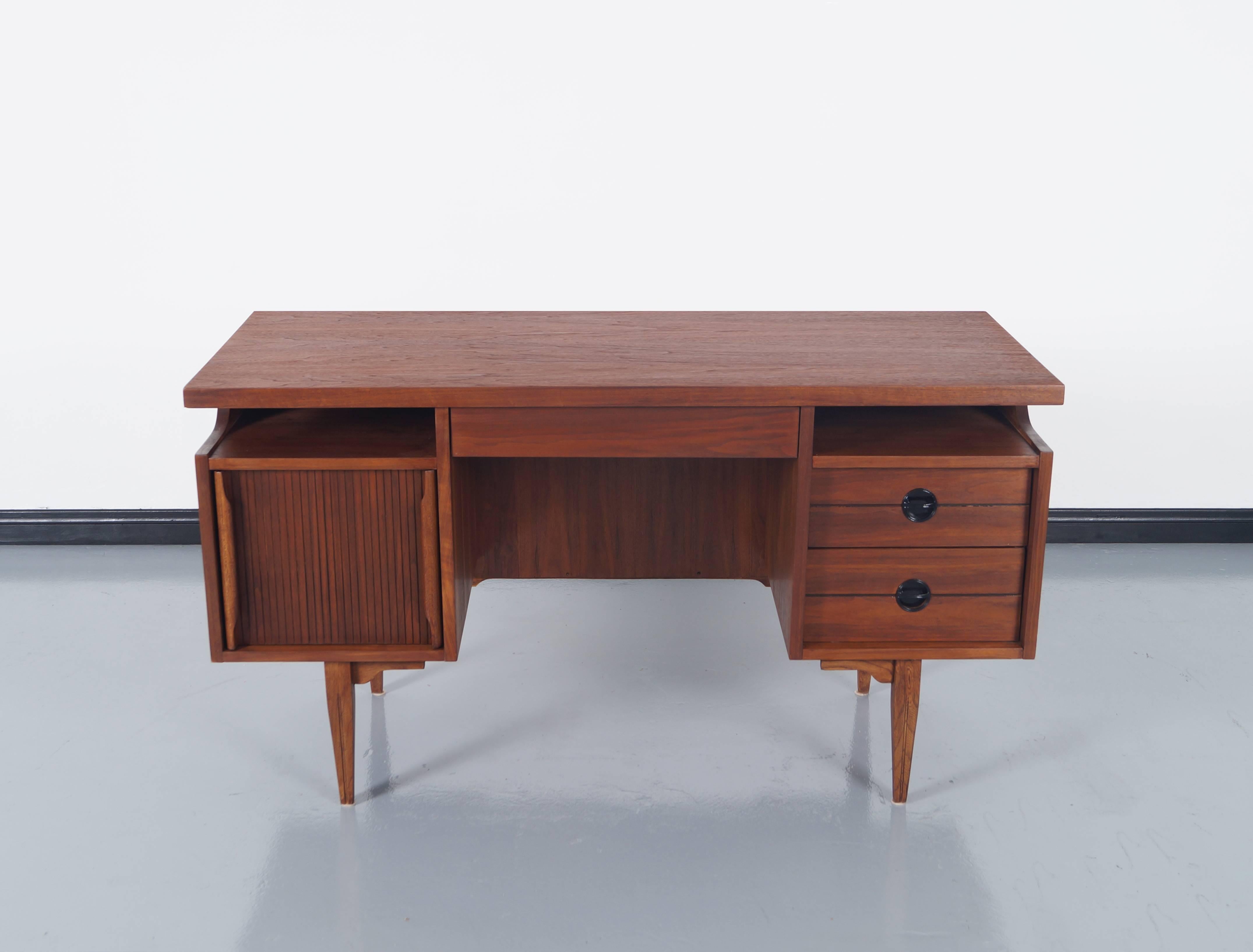 Mid-Century walnut desk by Mainline Hooker. Features five dovetail drawers in total with a large file drawer.