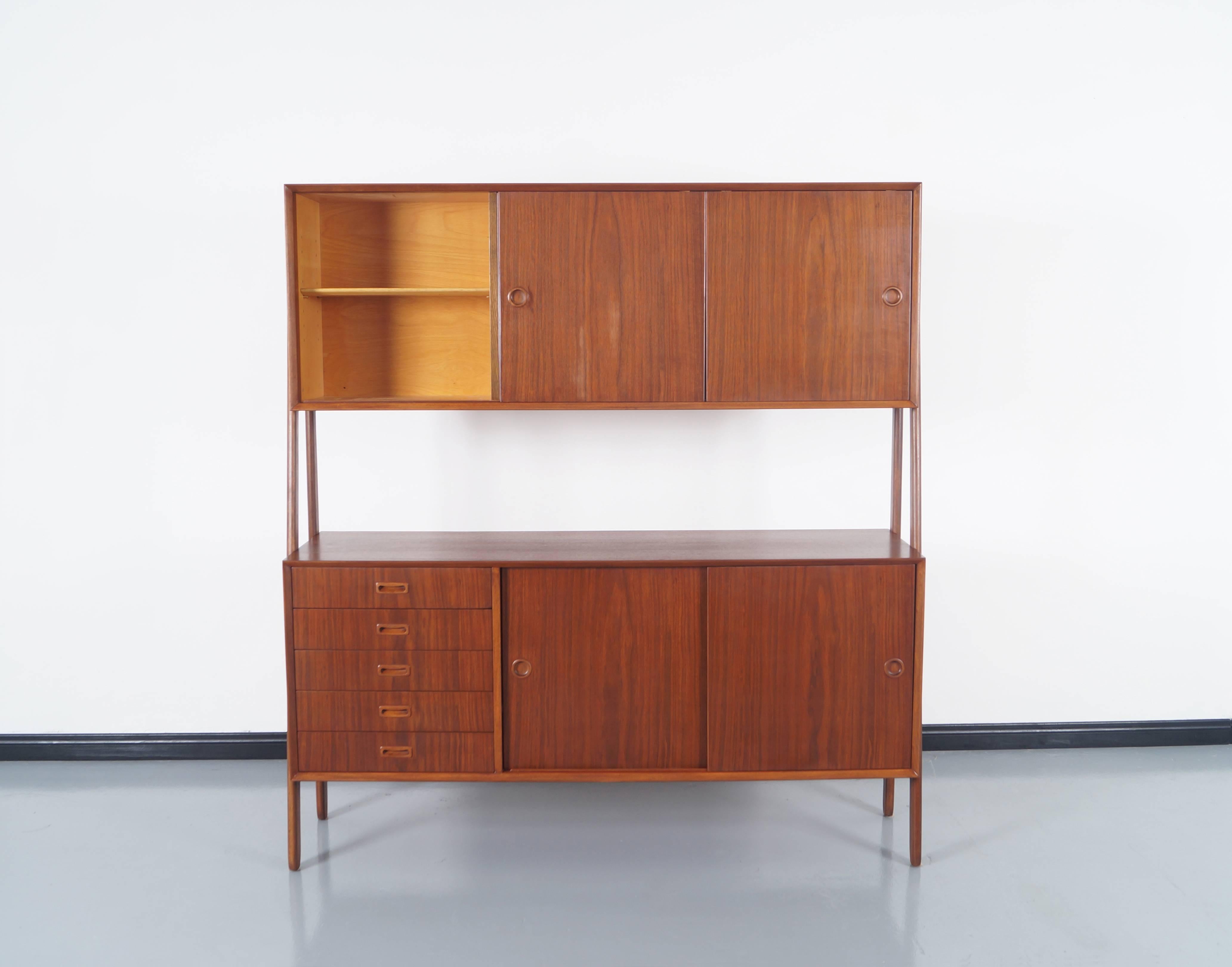 Stunning Danish Modern sideboard by Gunni Omann. The upper portion has sliding doors which open to reveal adjustable shelving, and the lower portion has five drawers on the left side and two sliding with one adjustable shelf inside. Although it