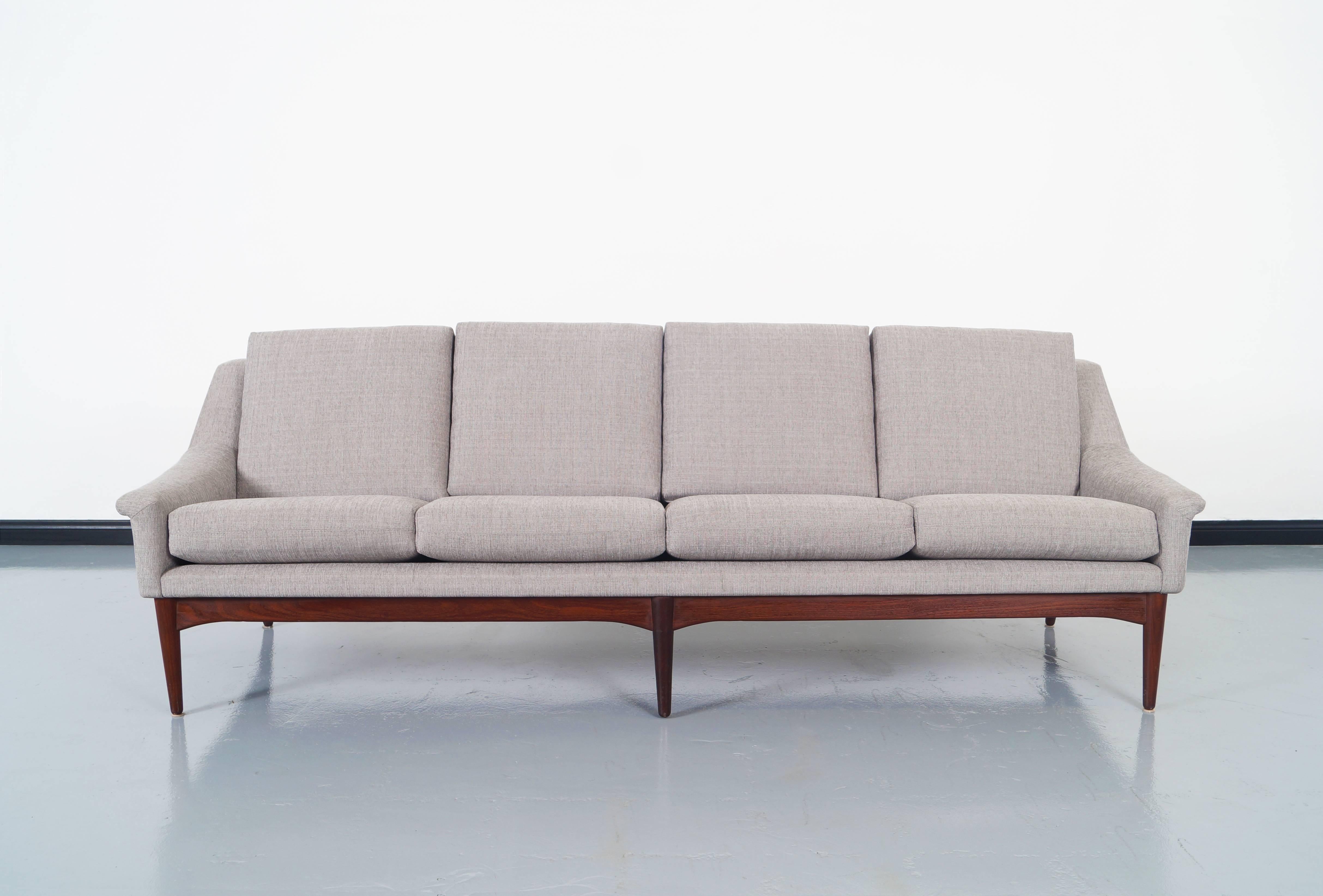 Beautiful Danish modern teak sofa attributed to Folke Ohlsson for Dux of Sweden, circa 1950s. This sofa has been professionally reupholstered in a gray tone fabric. It has elegant lines as well as comfortable cushions that give a unique experience