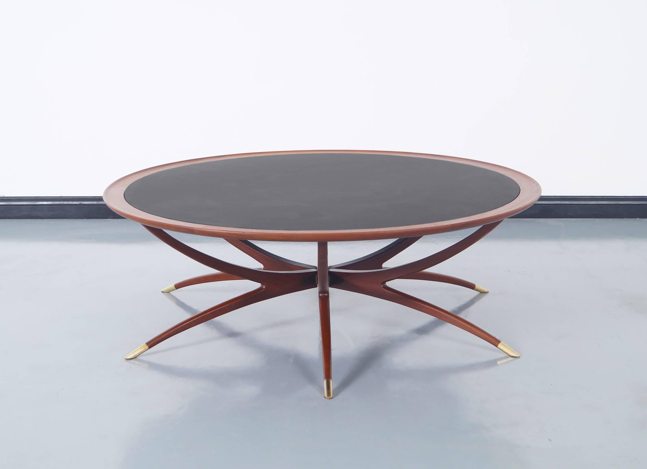 Stunning vintage spider leg coffee table attributed to Carlo Di Carli, circa 1960s. This coffee table has an avant-garde design, highlights the solid walnut frame that supports a circular glass top. It has 6 sculptural legs, all covered at the