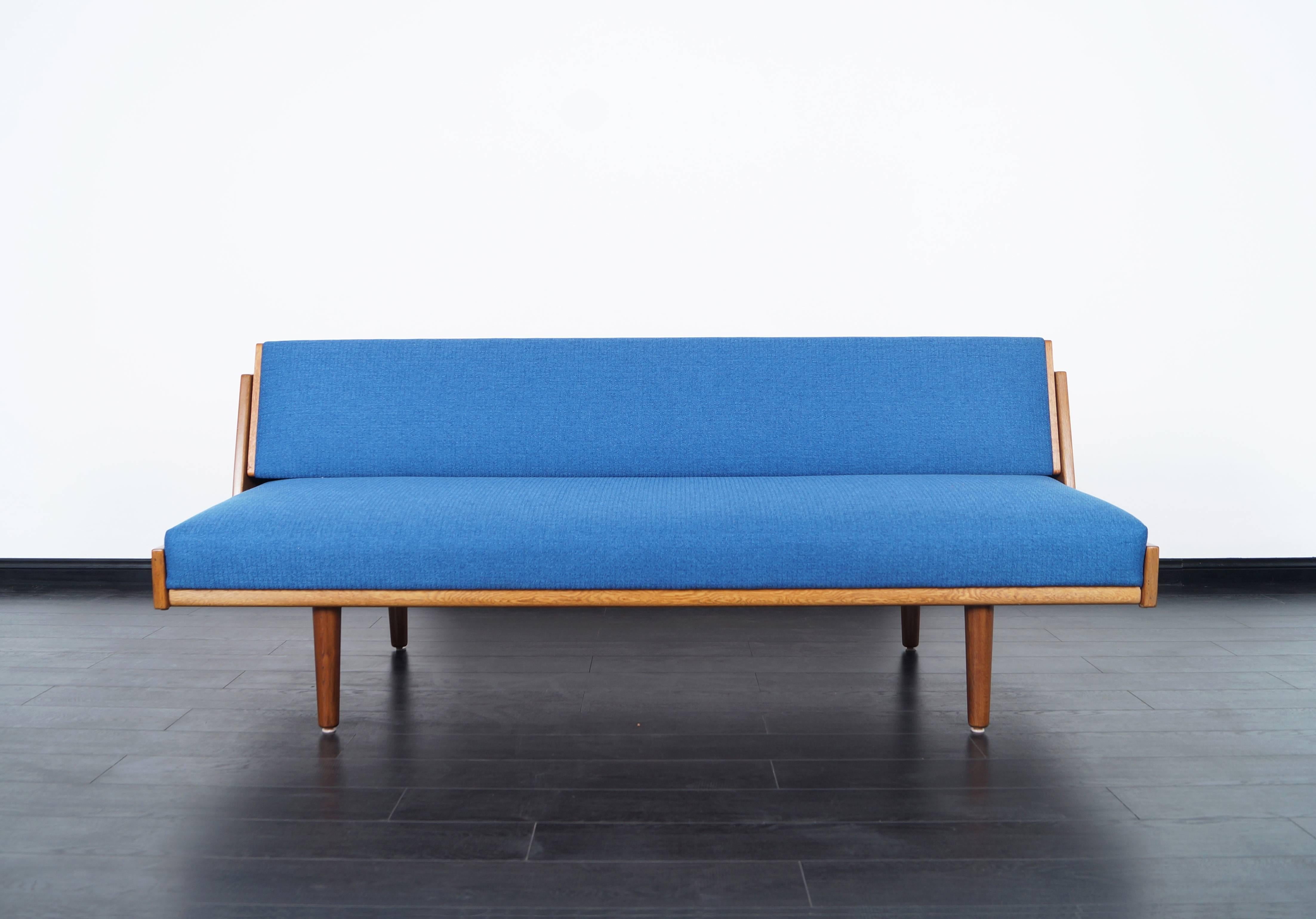 Danish modern daybed designed by Hans Wegner for GETAMA. Features a backrest that lifts up and locks in place to expose a size of a twin bed. Gives more space for lying down. Engraved with original designer label.
