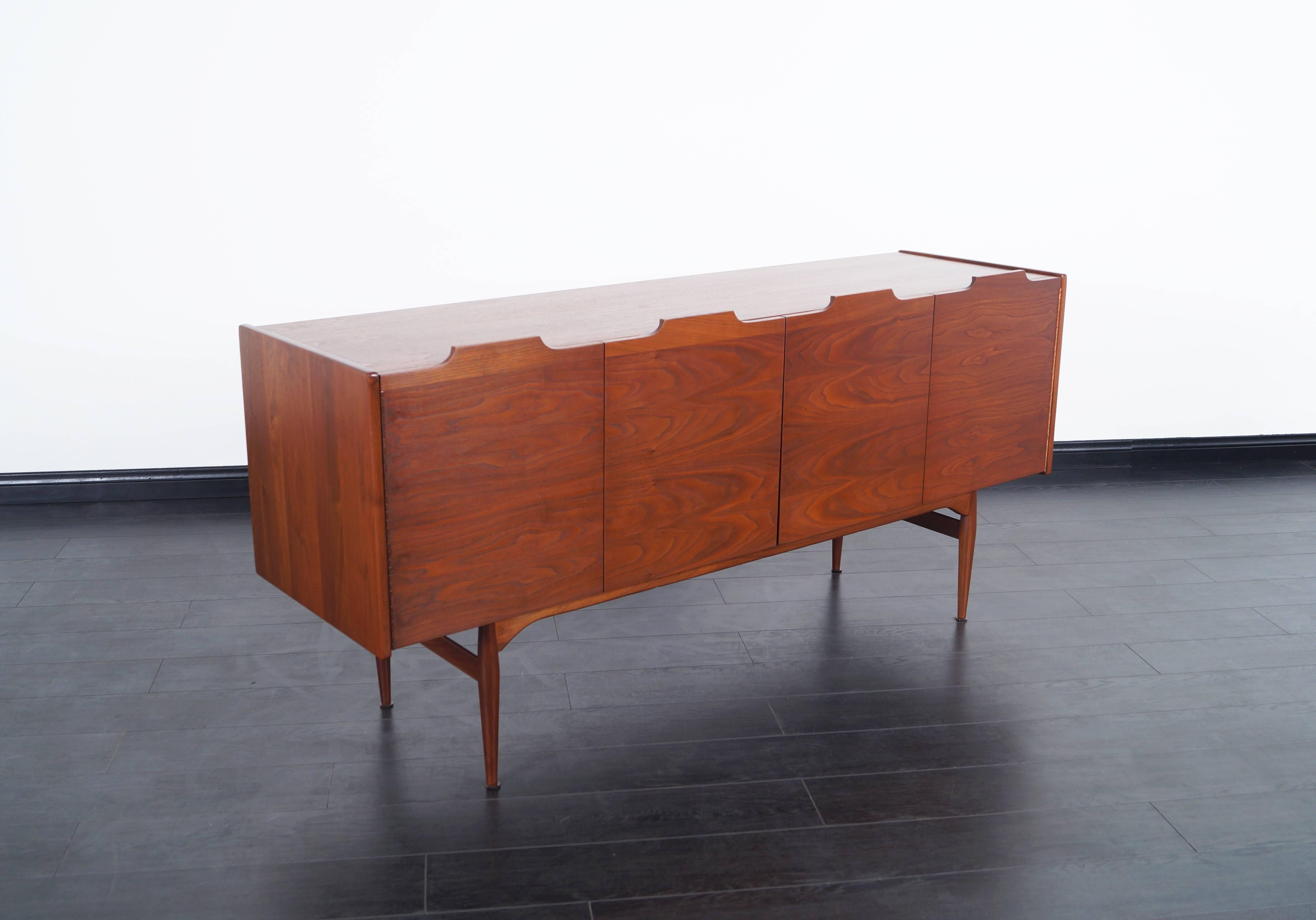 Exceptional vintage walnut credenza designed by John Caldwell for Brown Saltman in the United States, circa 1950s. This credenza stands out for a smooth design around the case that allows us to better appreciate the elegant grains of the walnut that