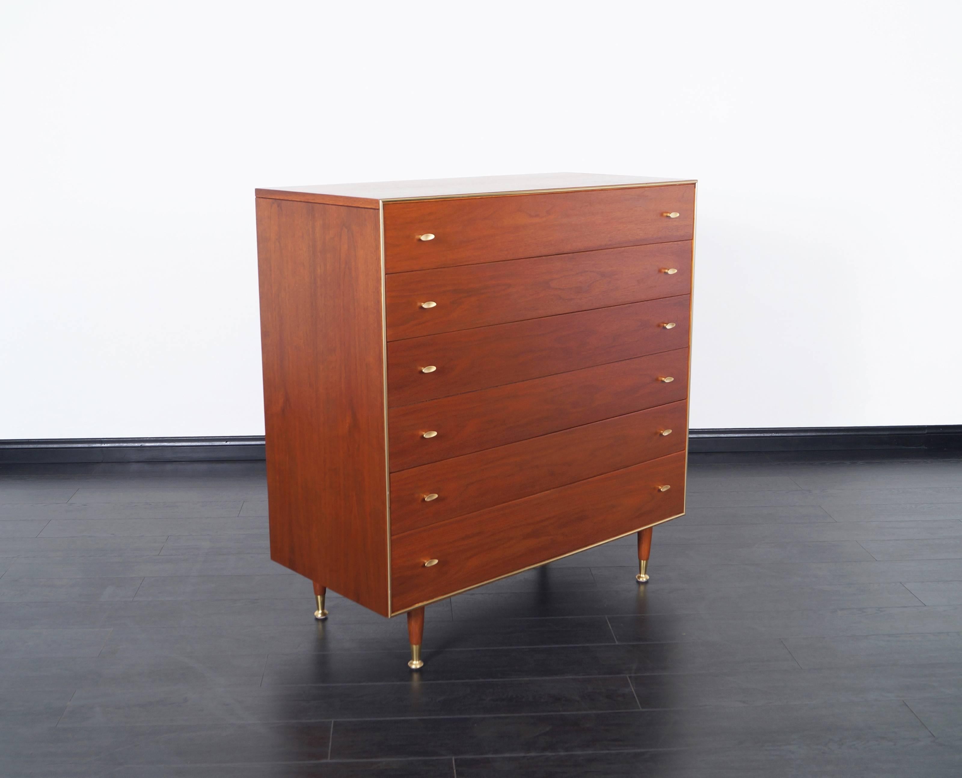 Mid-Century Modern walnut highboy by R-Way. Features five dovetail drawers with solid brass feet. Handles are stained in a brass finish.