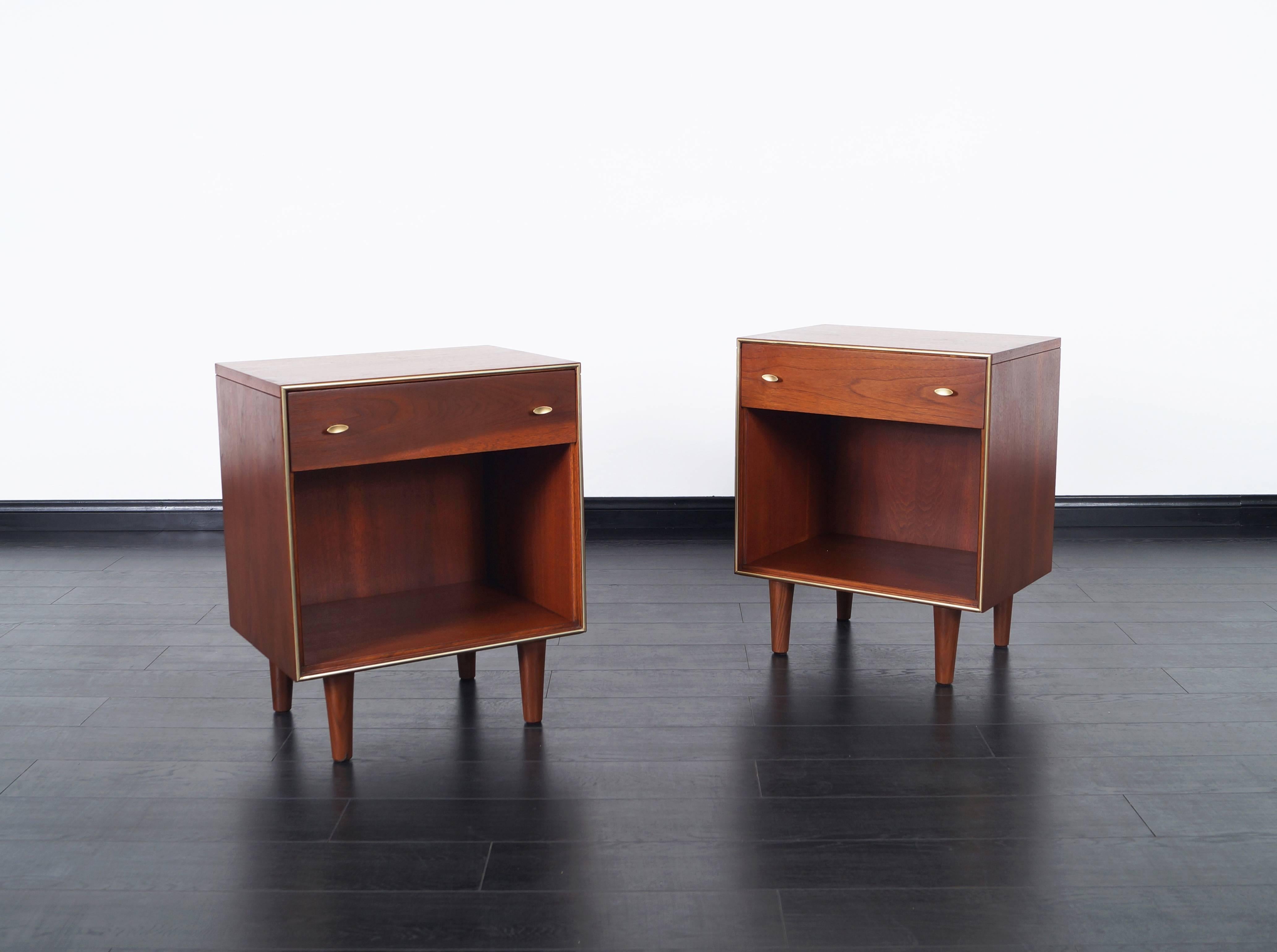 Pair of fabulous Mid-Century Modern walnut nightstands by R-Way. Each nightstand features one pull-out drawer with open storage underneath. Handles are stained in a brass finish.