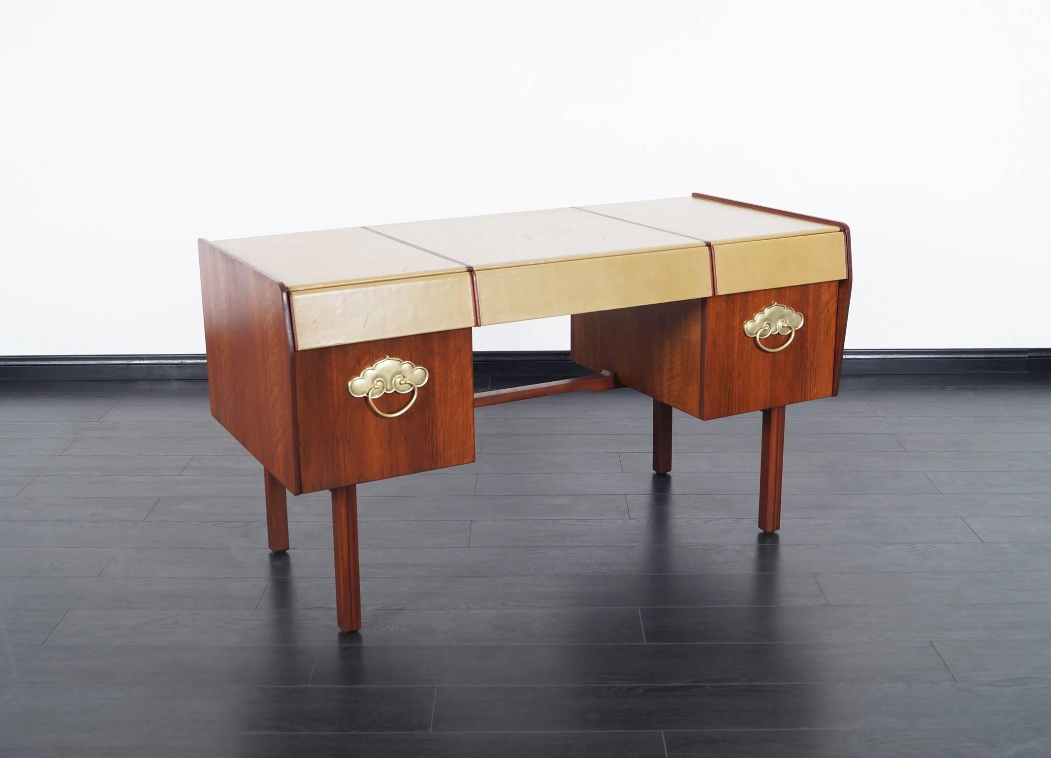 Fabulous leather top desk designed by Bert England for John Widdicomb. Features two file drawers on either side, above are three pull-out drawers.