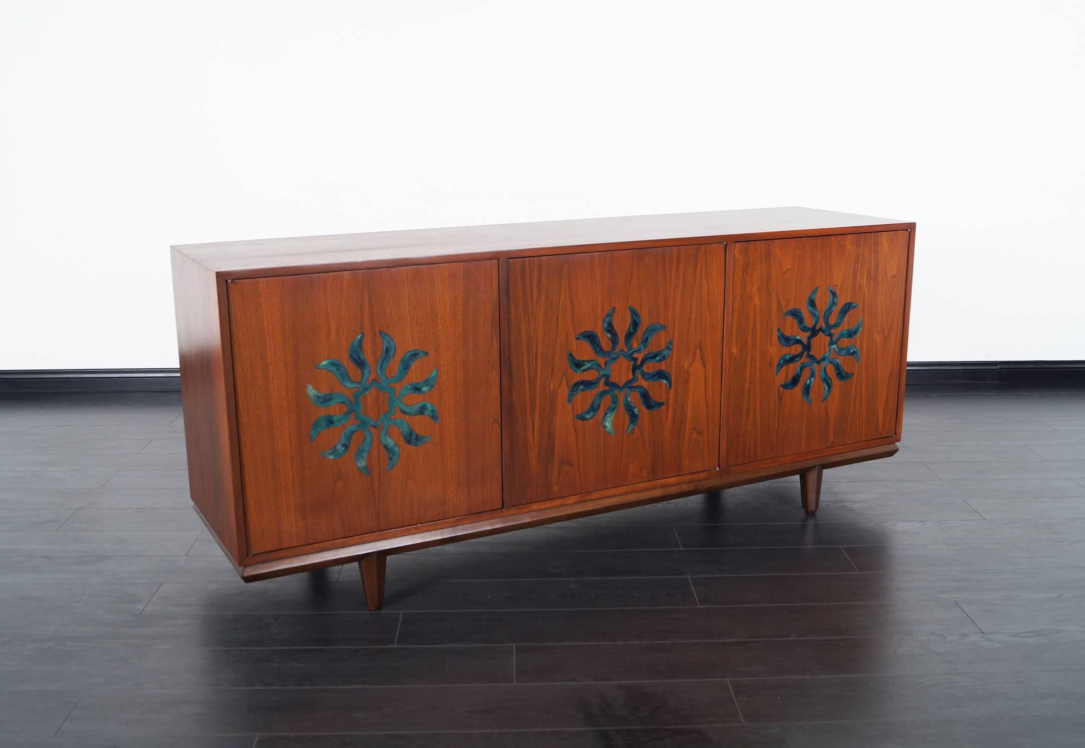 Vintage walnut credenza attributed to Monteverdi Young. This fabulous was produce by Cal Mode in South California. Features stunning starburst medallions on each door.