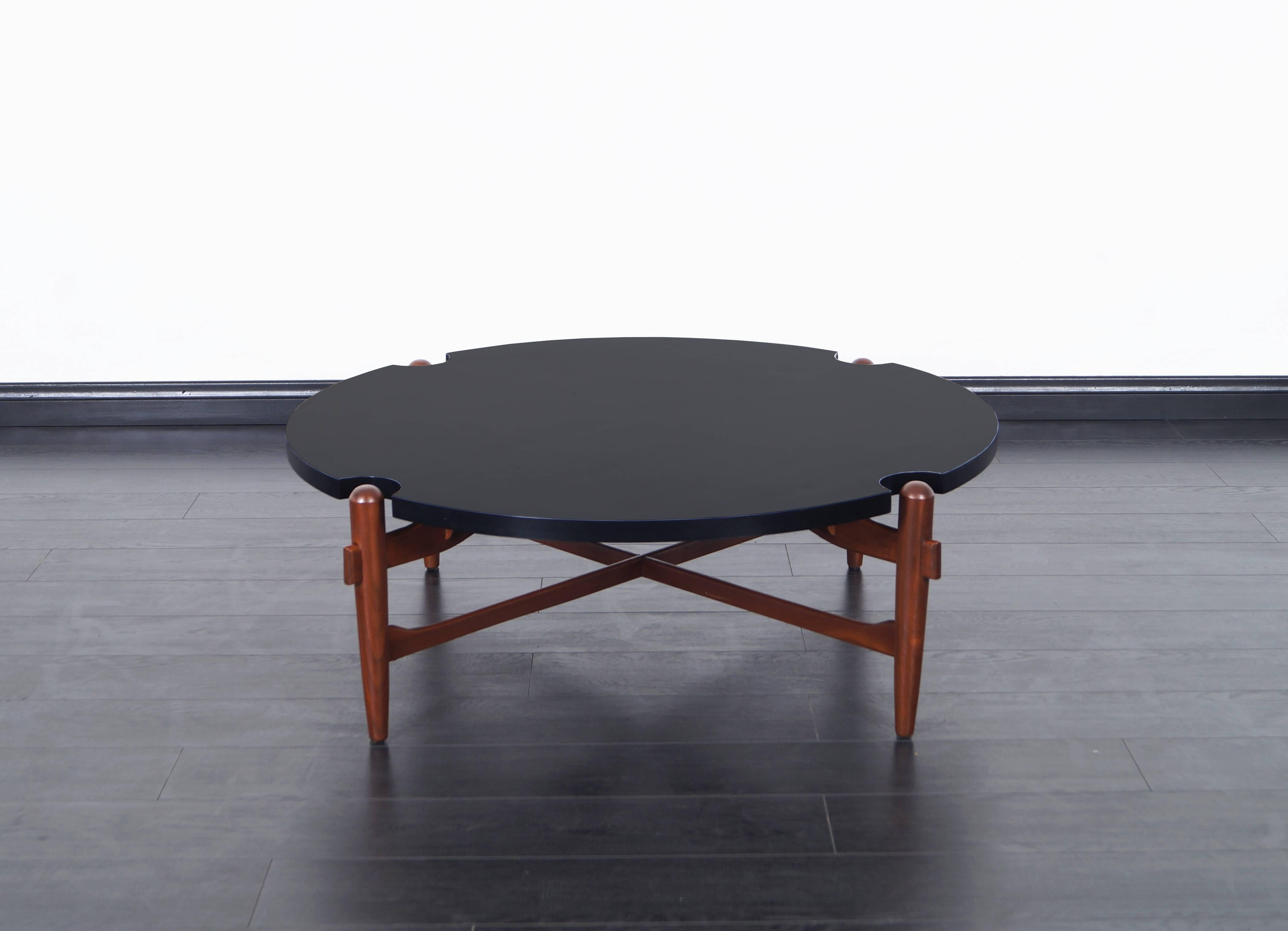 Vintage walnut coffee table features a round black laminate top with sculptural wood base. This coffee table is attributed to Greta M. Grossman.