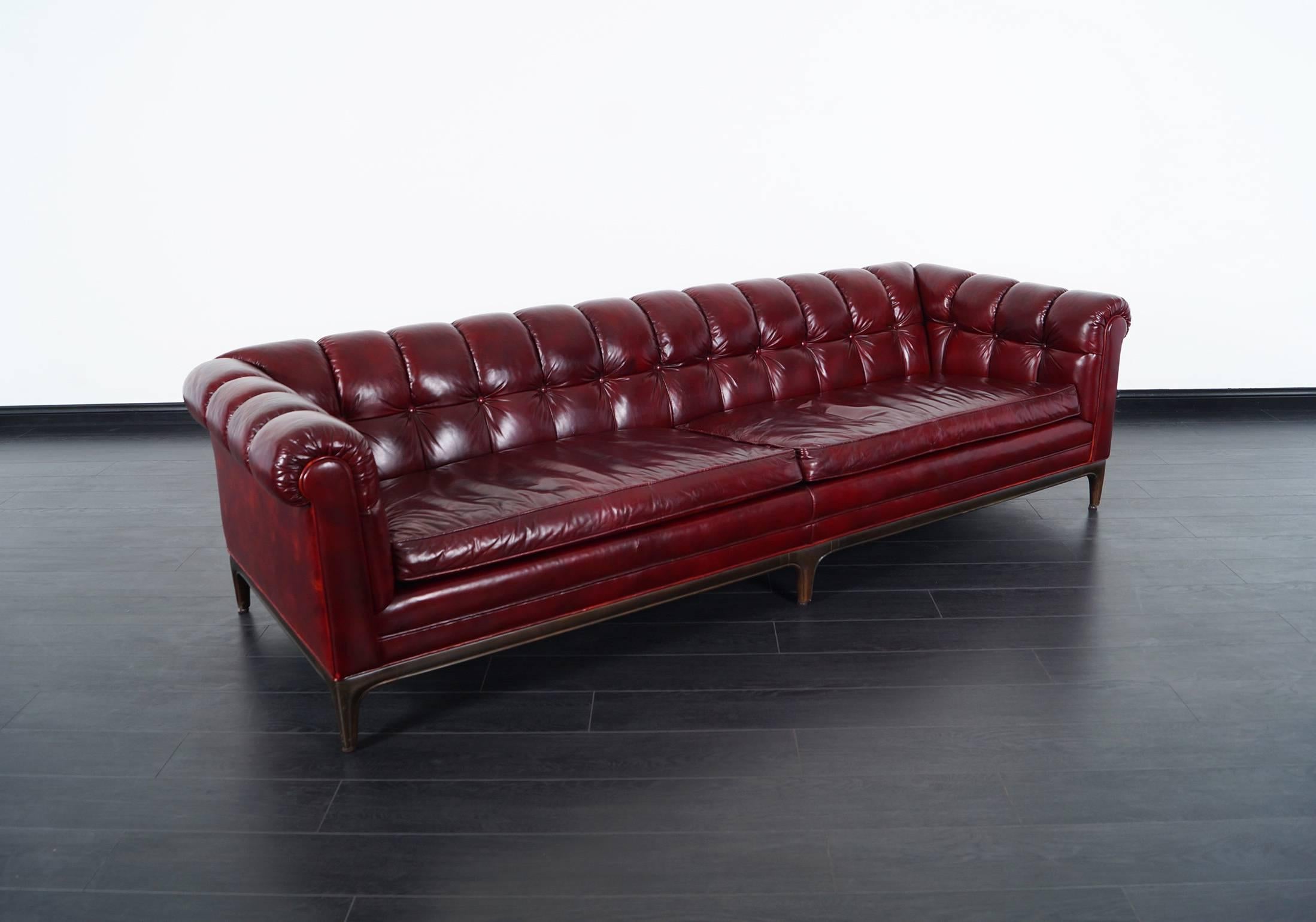 Stunning vintage biscuit tufted leather sofa designed by Maurice Bailey for Monteverdi Young in United States, circa 1960s. This remarkable sofa features a solid walnut sculptural base and its original leathery upholstery displaying a beautiful