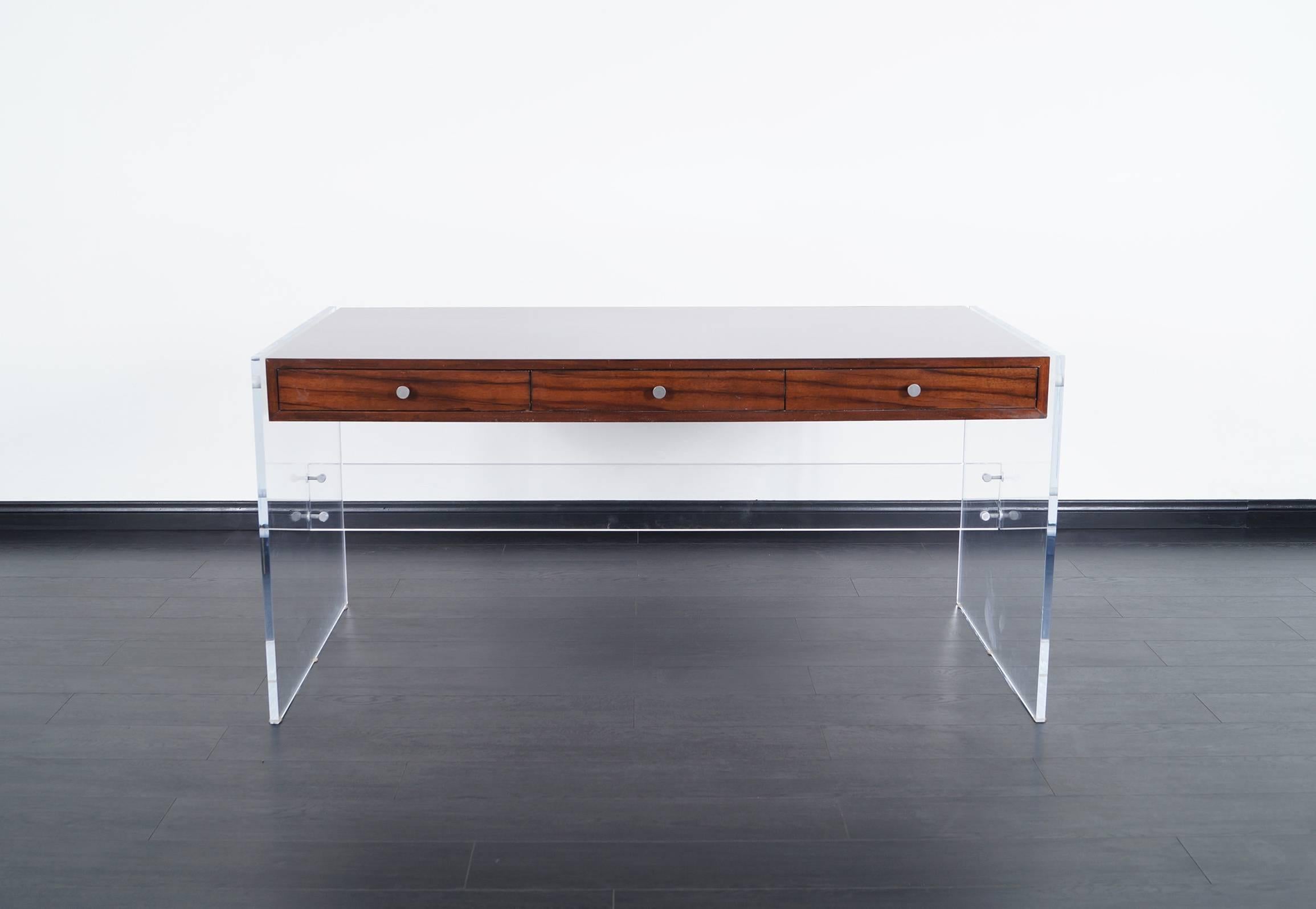 Fabulous modernist desk by Helen Aumont. Made from dark mahogany with Lucite bases which gives the illusion of a floating case.