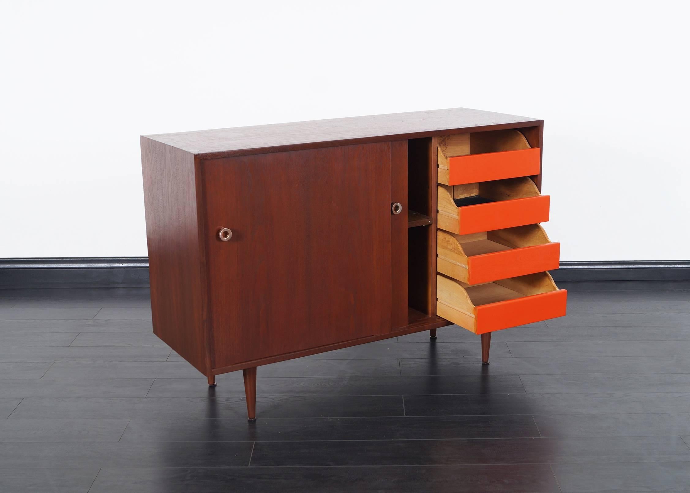 Vintage walnut credenza by Greta M. Grossman for Glenn of California. Inside contains one adjustable shelf on the left side and four pull-out drawers to the right.