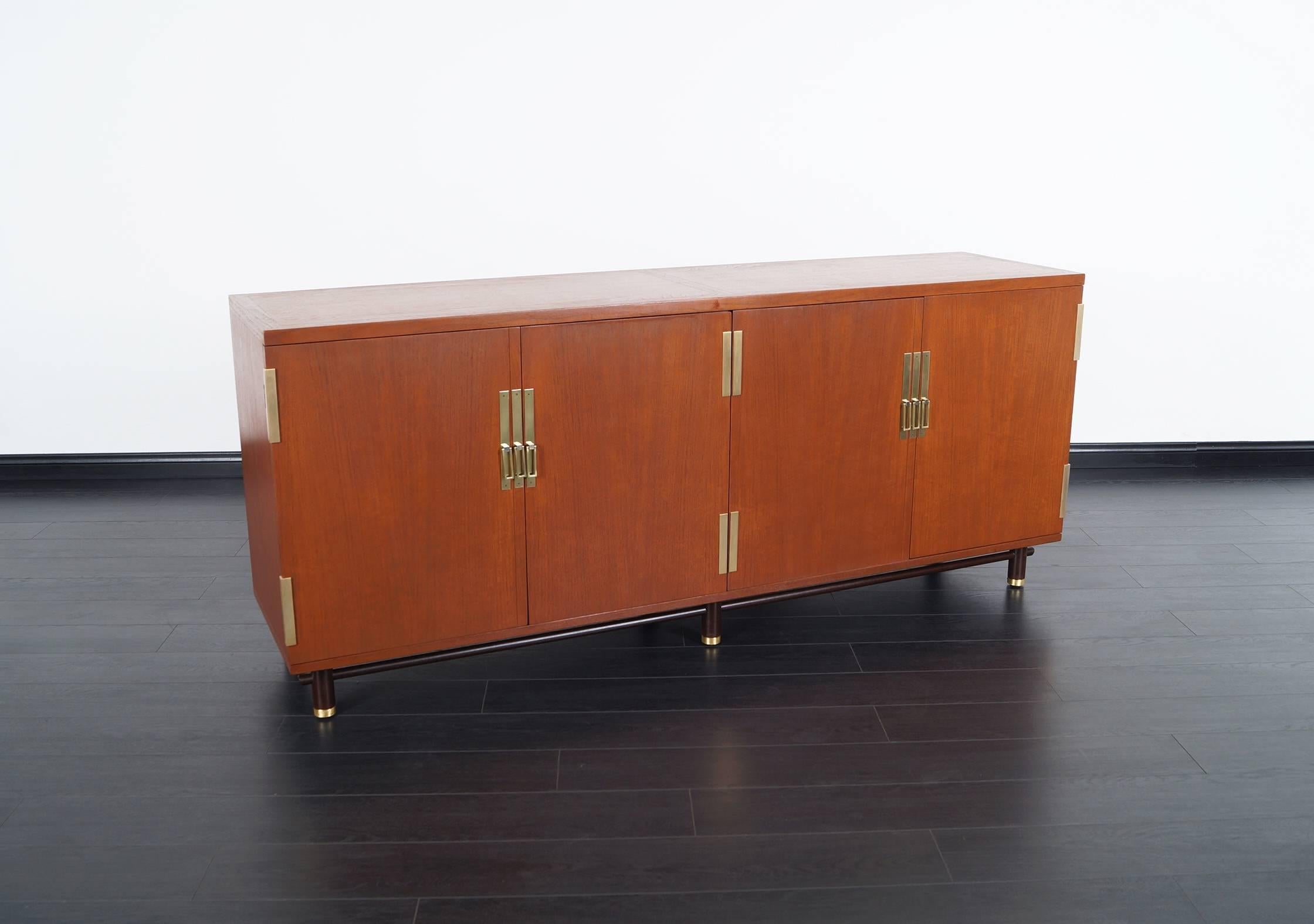Mid-Century credenza designed by Michael Taylor for Baker. Features four pull-out drawers on the left side, one shelf to the right and solid brass hardware throughout the piece.