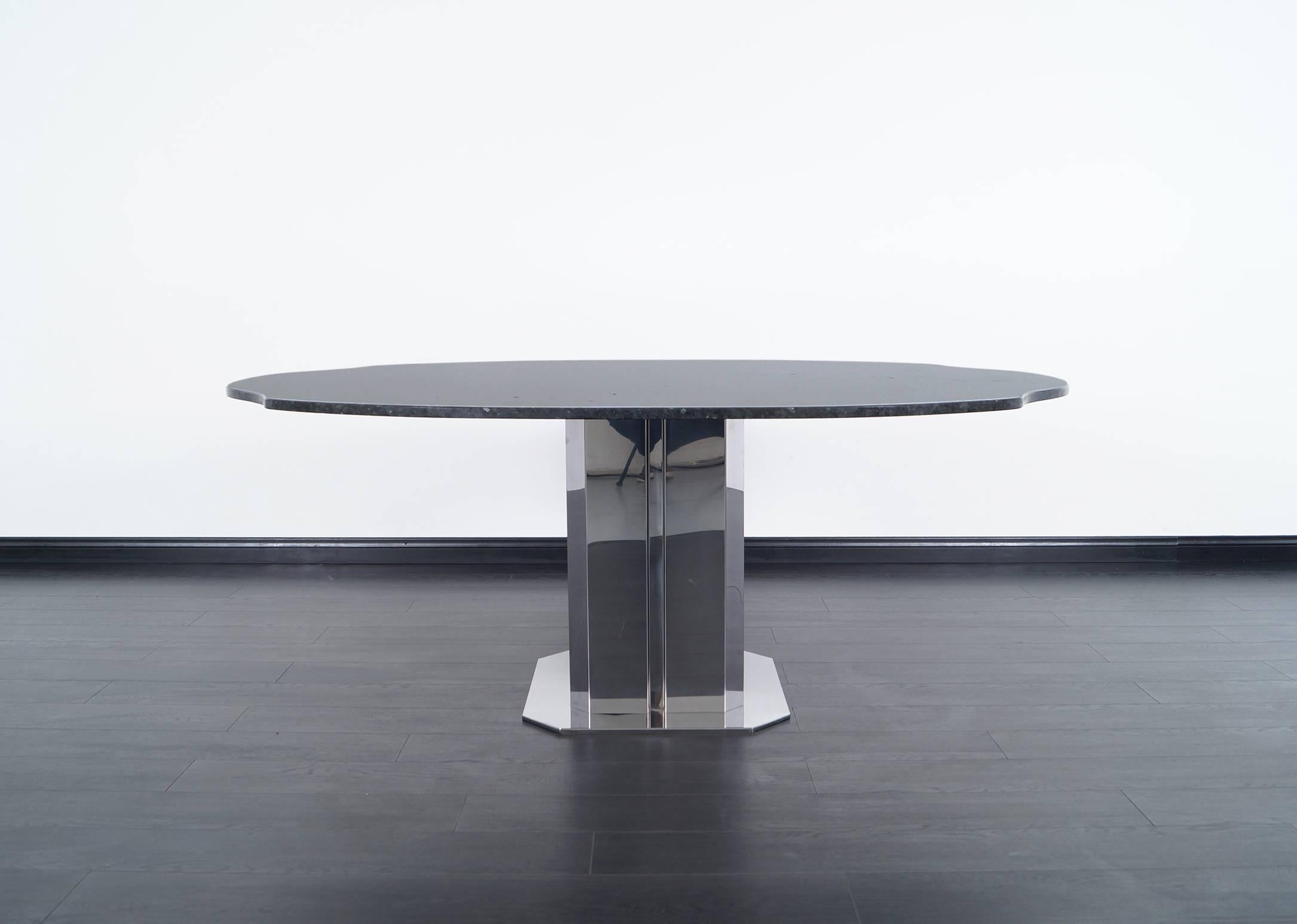 This stunning vintage Italian dining table attributed to Antonia Astori. Features a custom granite top with chrome-plated base.