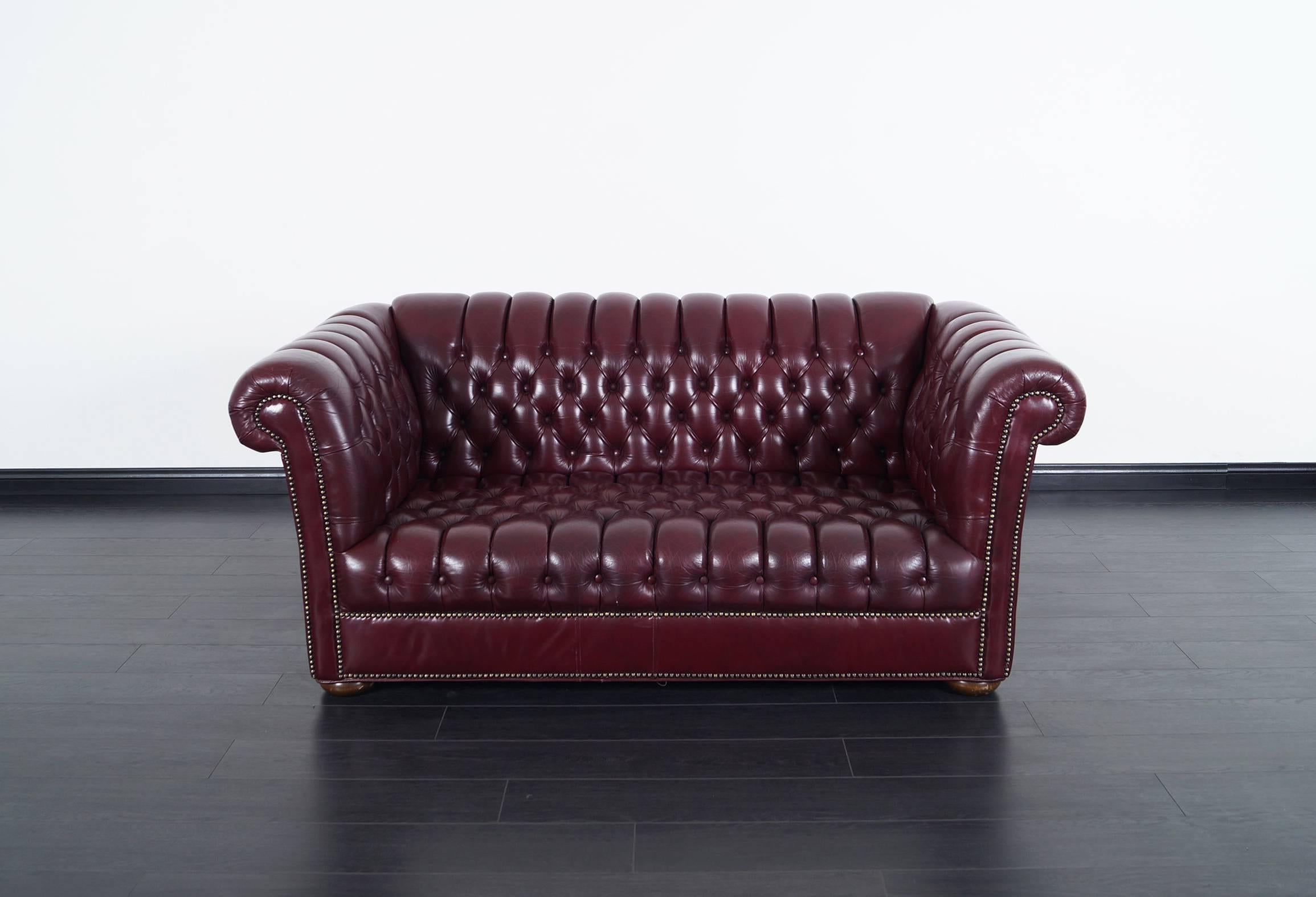 This beautiful burgundy Chesterfield loveseat makes perfect seating for any interior.