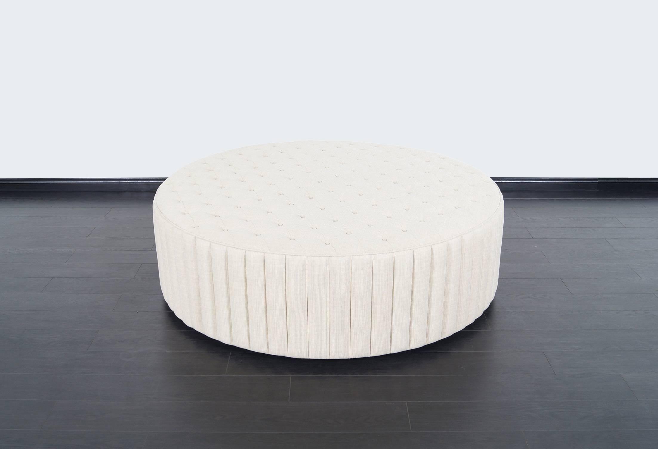 This fabulous oversized tufted ottoman has been newly reupholstered. This piece can also be used as a coffee table or extra seating. Sits on a black wooden base.