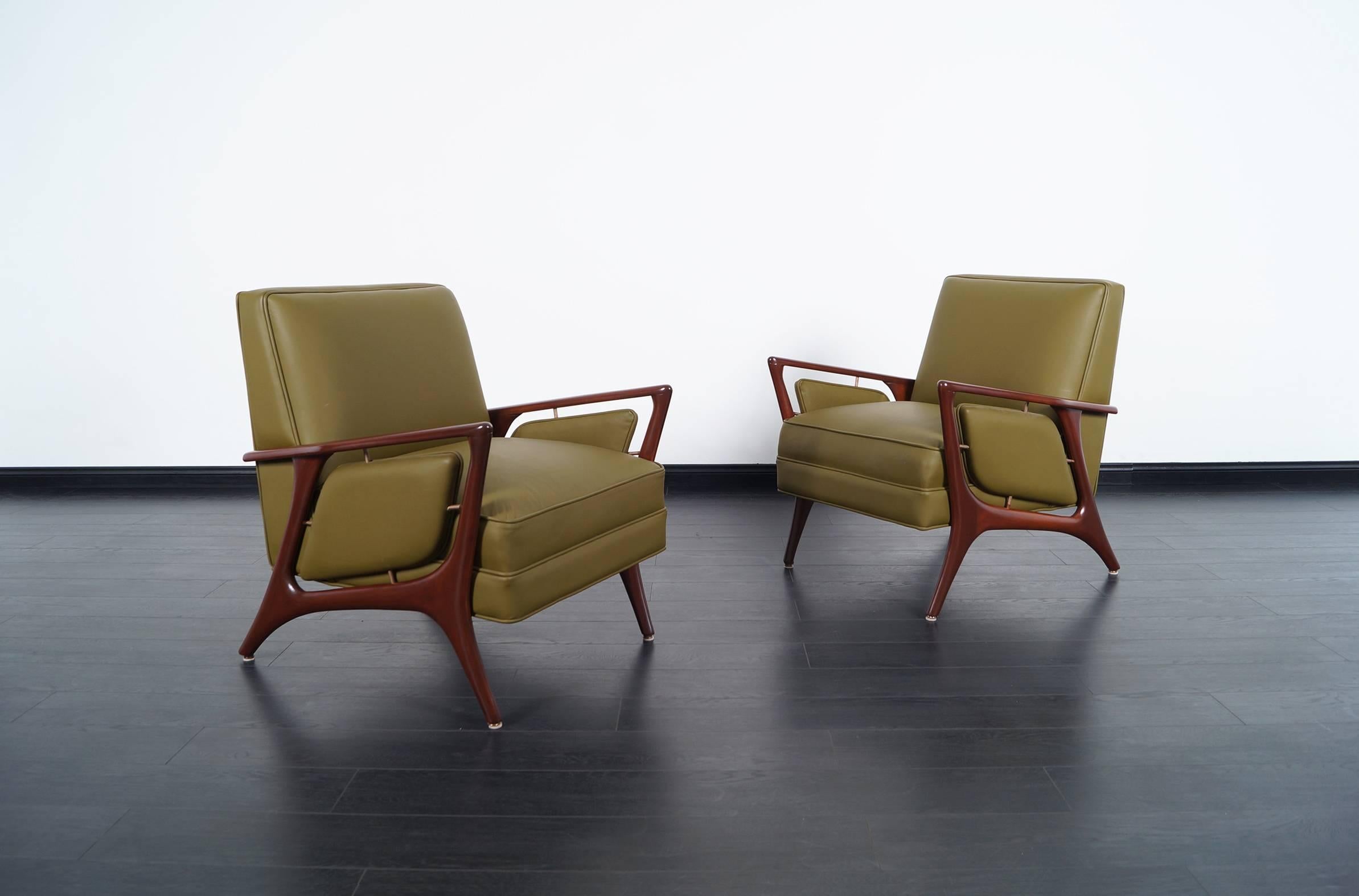 Pair of fabulous modernist lounge chairs designed by Eugenio Escudero. Features sculptural frame with brass details and leather upholstery.