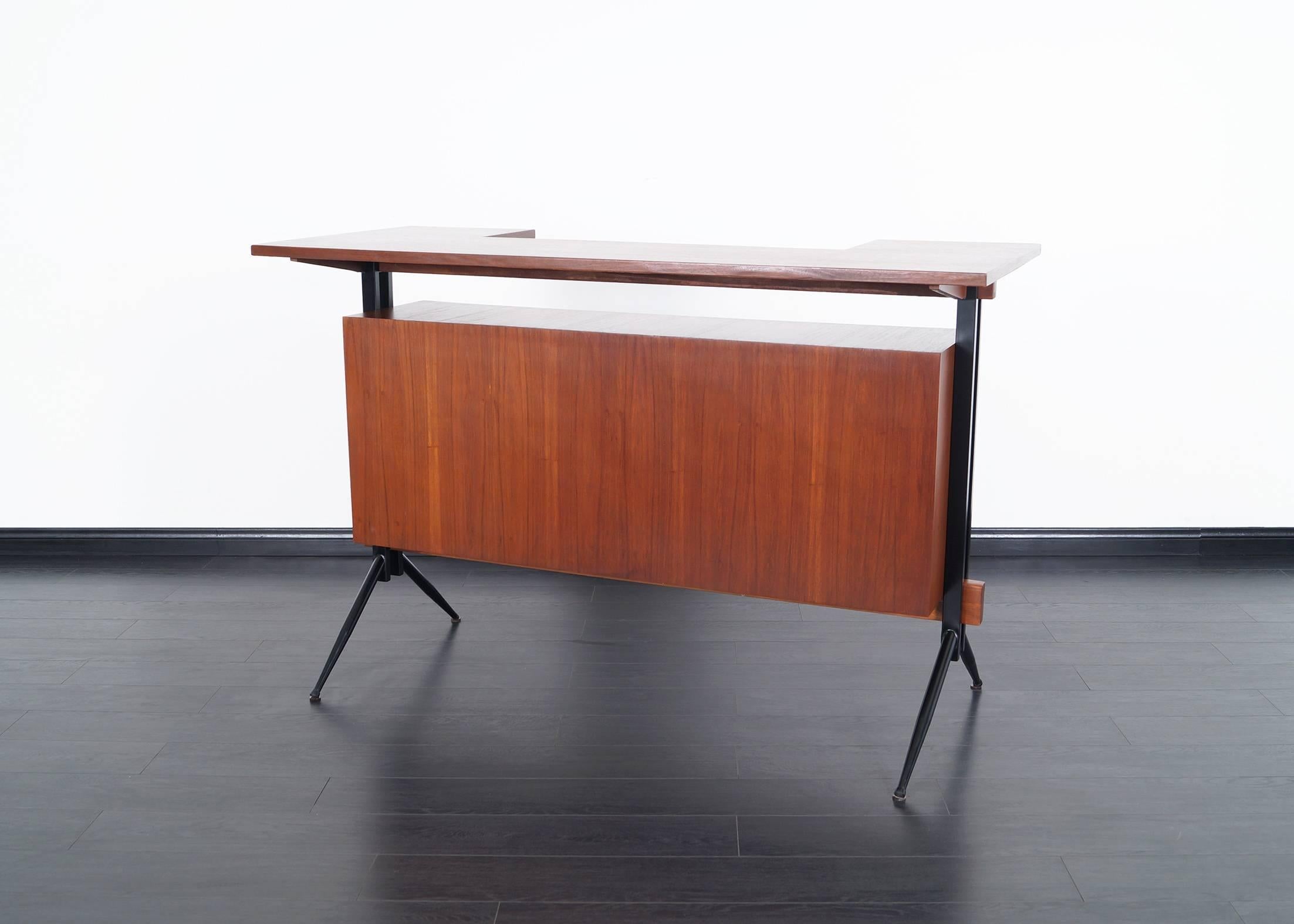 Mid-Century Modern walnut bar. Features a large working space and a storage compartment beneath, accessed by two sliding doors.