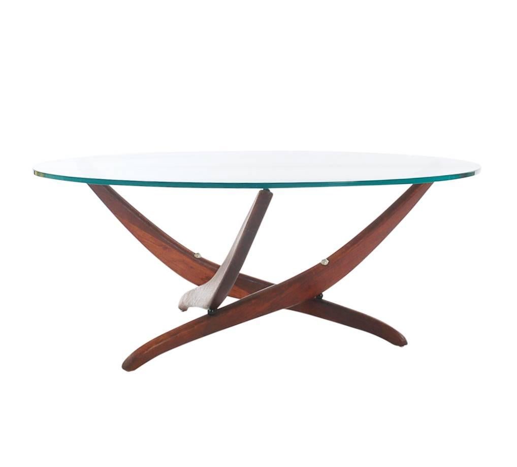 A Minimalist and striking design by Forest Wilson, circa 1960s. It features a solid walnut three leg base and a heavy thick glass top. 

In the style of: Adrian Pearsall, Gio Ponti, Vladimir Kagan.
