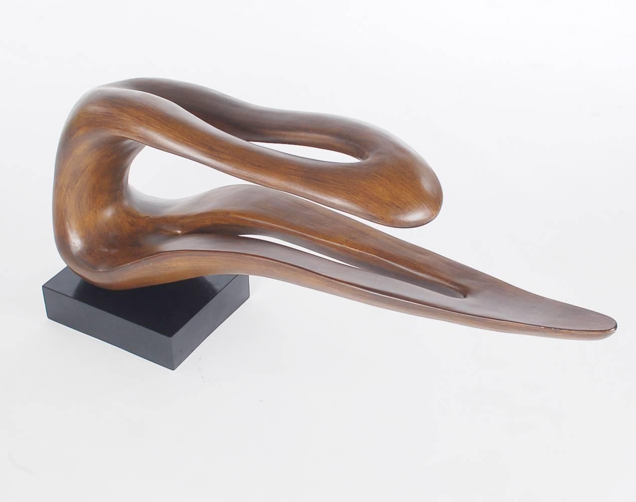 A large and impressive free-form mounted table sculpture. It consists of a heavy wood grained resin form, mounted on weighted wood base. Circa 1970's Unmarked

In the style of: Wendell Castle, Sam Maloof, Zaha Hadid