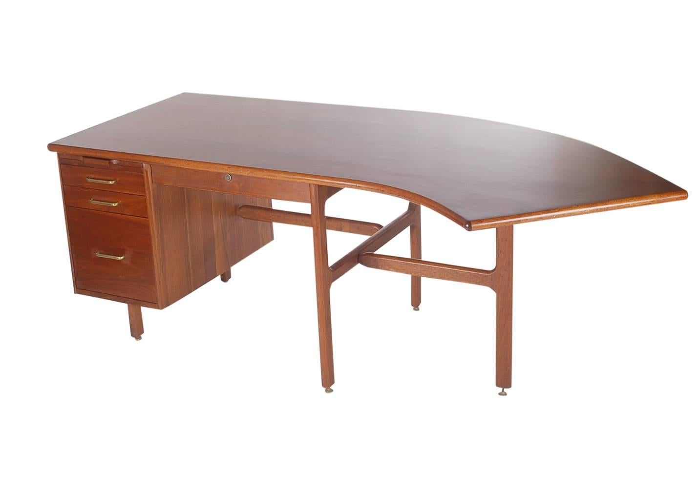 A large and unusual designed curved desk, circa 1960s. Extremely heavy and well built in solid walnut. Very well cared for through the years and ready for immediate use. 

In the style of: George Nelson, Jens Risom, Florence Knoll.