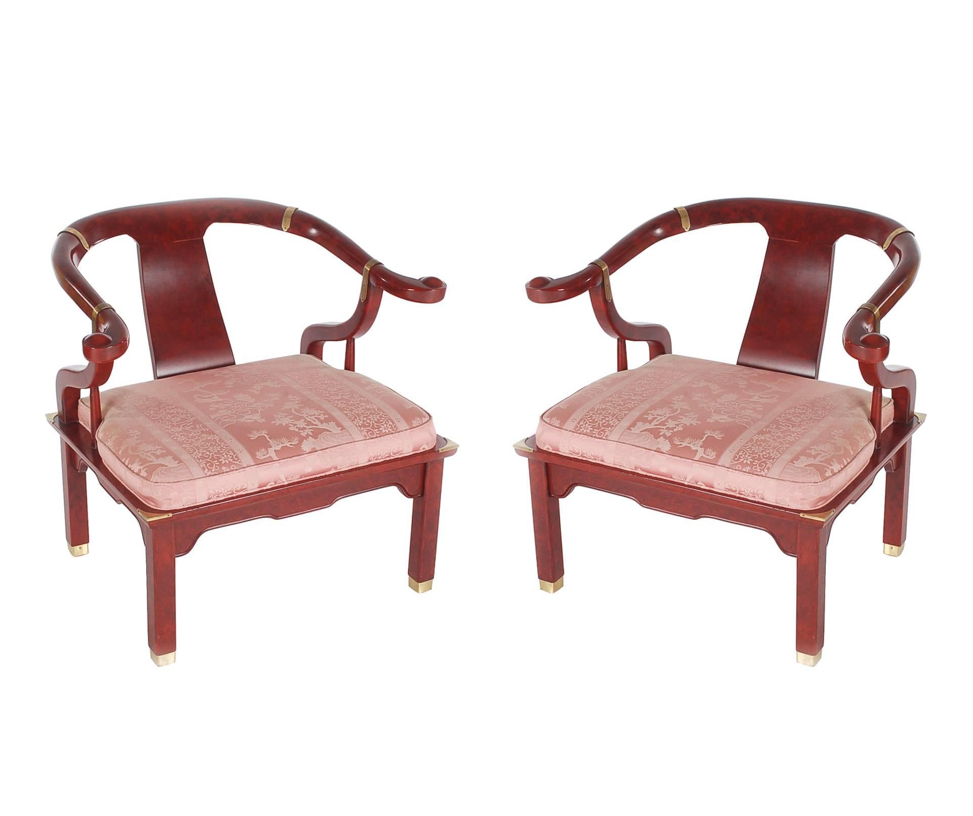 An iconic looking set of horseshoe back lounge chairs in the style of James Mont and made by Century. They feature a burgundy patinated finish, brass detailing and the original upholstery. We also have a matching settee available.