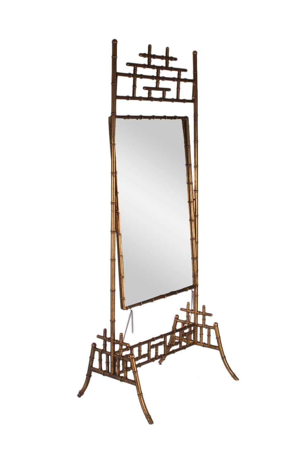 A large stately design Cheval mirror. It features a beautifully gold finish faux bamboo frame, with large pivoting mirror.