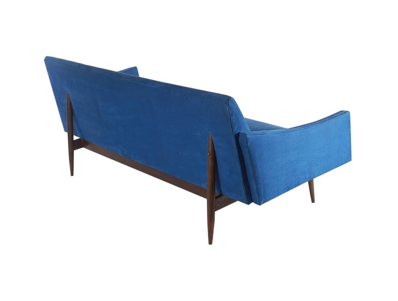 A very handsome Italian sofa with super sexy design lines. It features tapered walnut legs, swooping arm rests, and blue suede upholstery.

In the style of: Gio Ponto or Ico Parisi.
