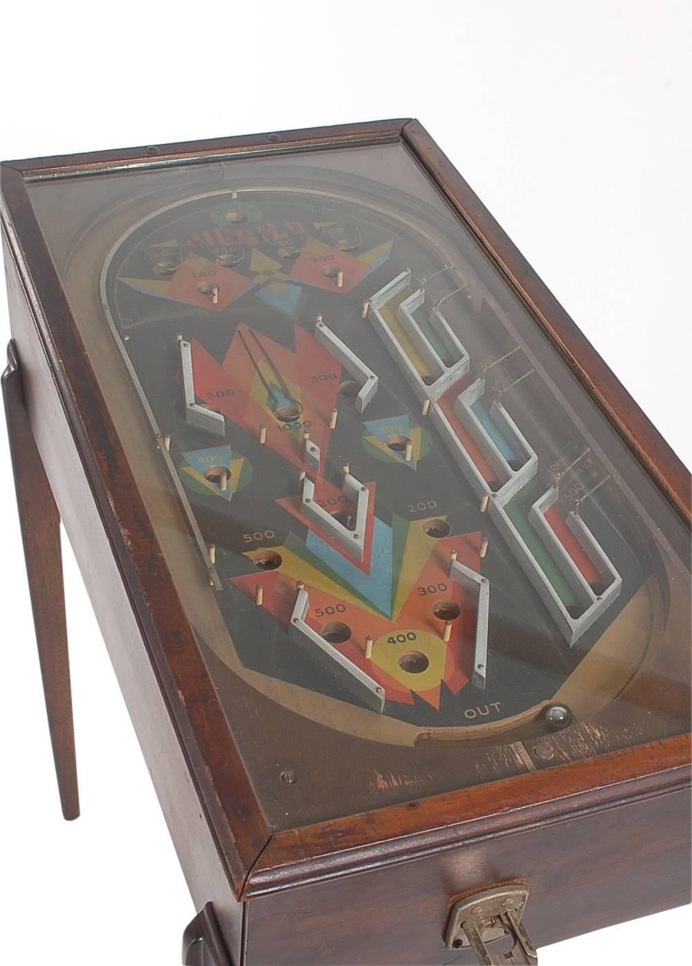 An early machine by Jiggilo from the 1930s Art Deco period. This is a pre-flipper pinball machine. It takes nickels, and is fully working. Comes with five pinballs.