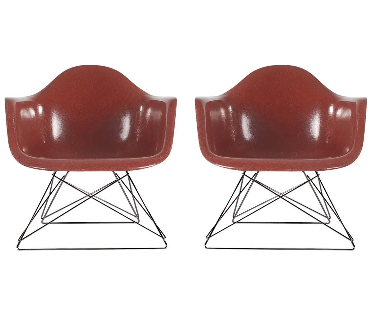 Here we have an iconic design classic from the Mid-Century Modern period. This vintage fiberglass shell chair was designed by Charles Eames and produced by Herman Miller, circa 1972. The chair seats are vintage and the low sitting cats cradle bases