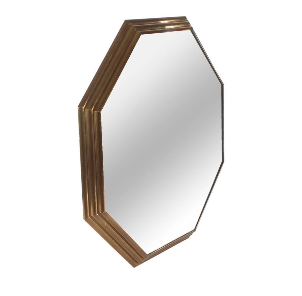 A simple, but stately wall mirror that will compliment any style decor. It features an Art Deco style stepped brass frame with large mirrored surface.