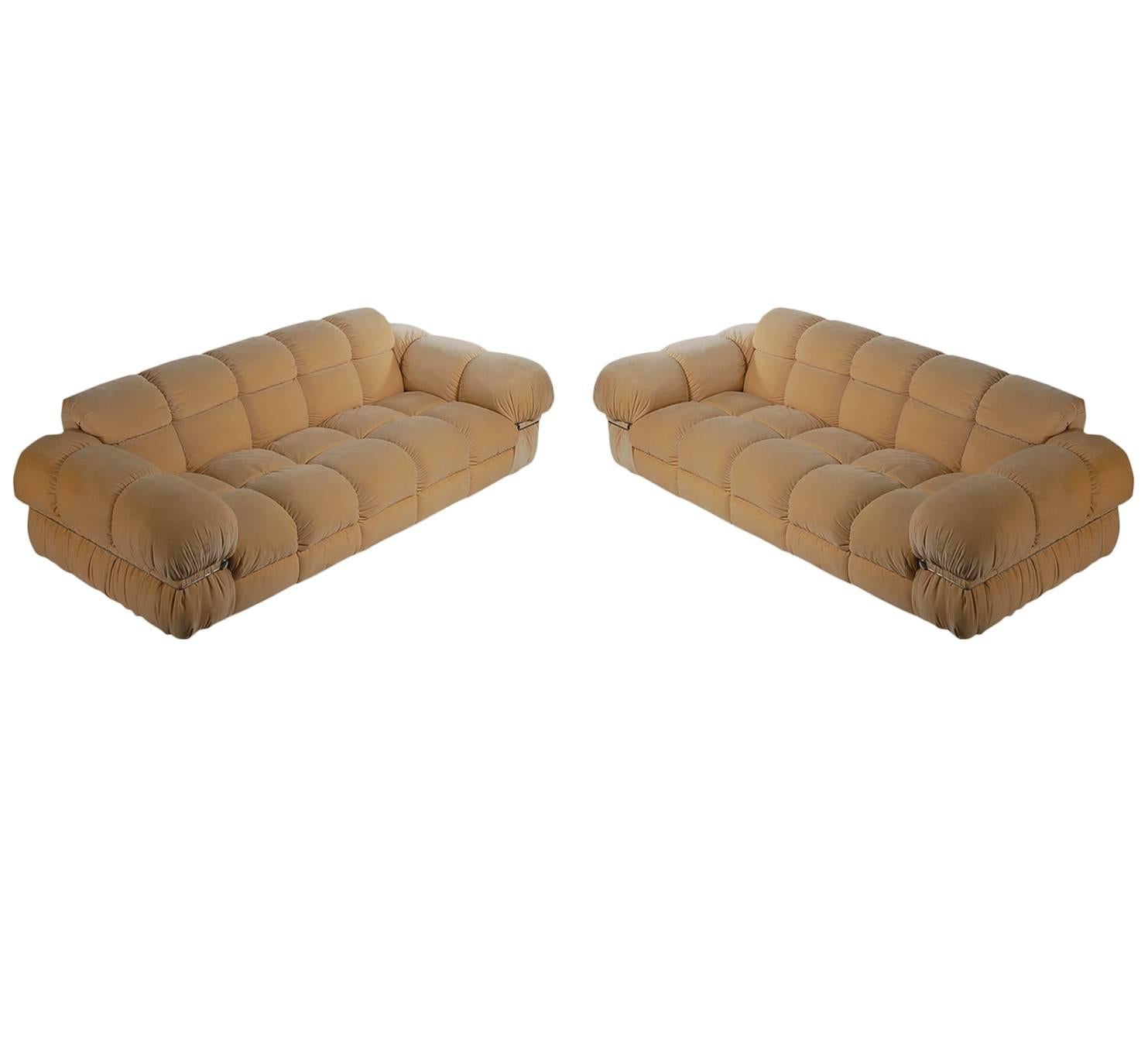 A very handsome matching pair of Italian sofas in the style of Mario Bellini's Camaleonda design. They feature, highly tailored upholstery, small casters feet, done in a cream colored microfiber. Very clean original condition.